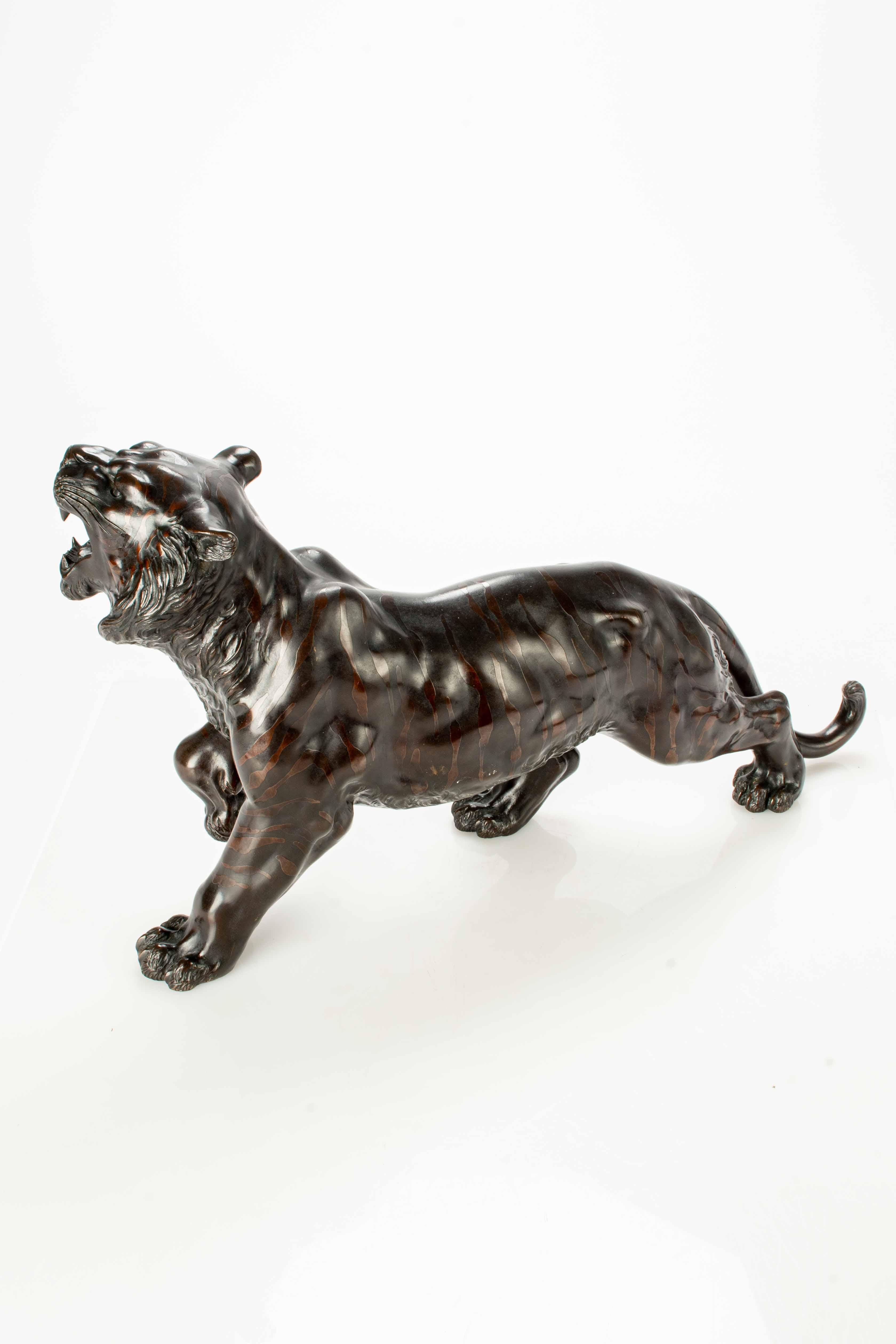 Japonisme A dark patina bronze okimono depicting the study of a powerful tiger 