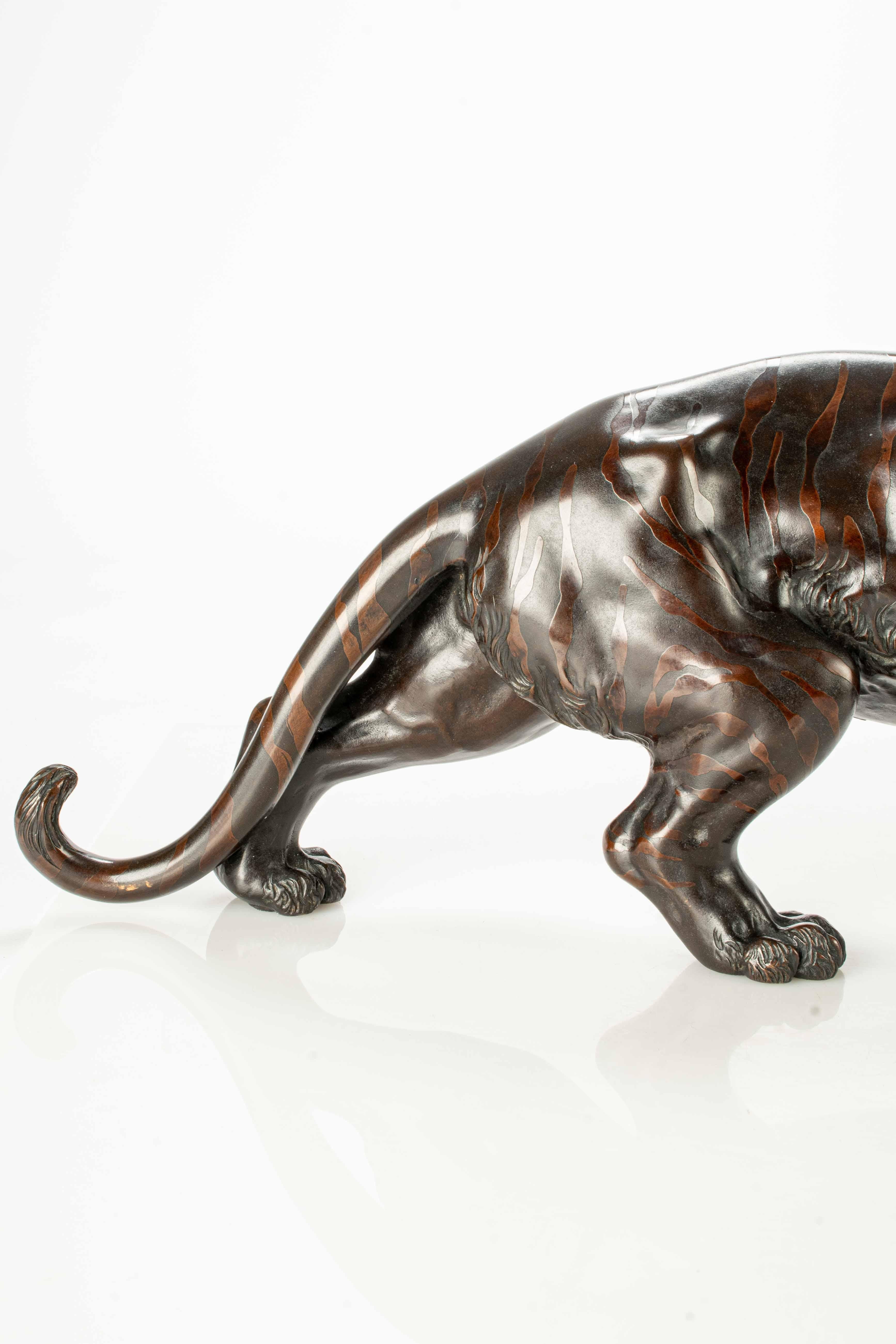 Bronze A dark patina bronze okimono depicting the study of a powerful tiger 