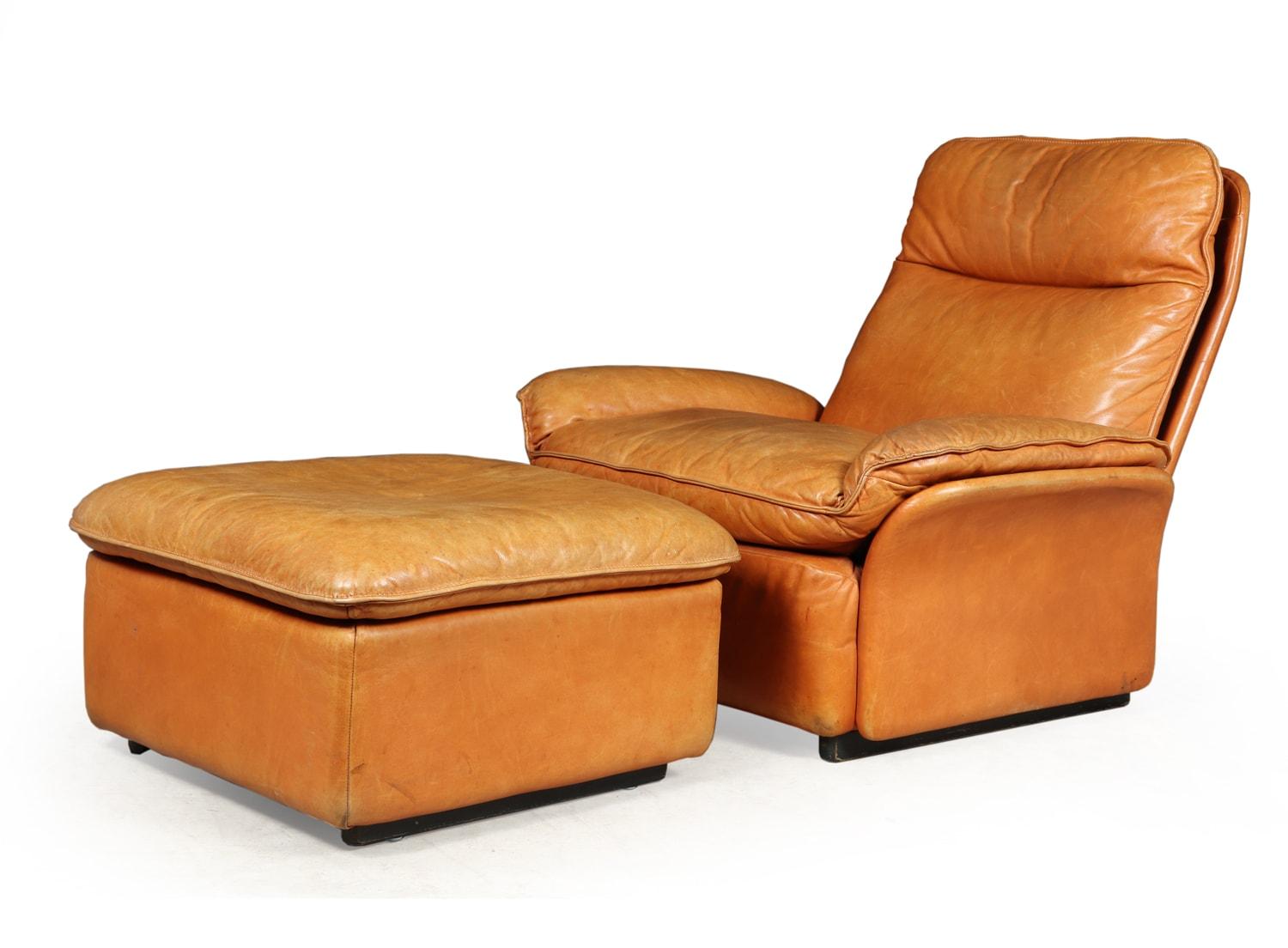 A De Sede leather armchair and foot stool model DS49

Original 1960s production of a DS-49 and foot stool in thick tan leather. Produced in Swizerland and is a Mid-Century Modern piece. The chair features a push spring back recline with the chair