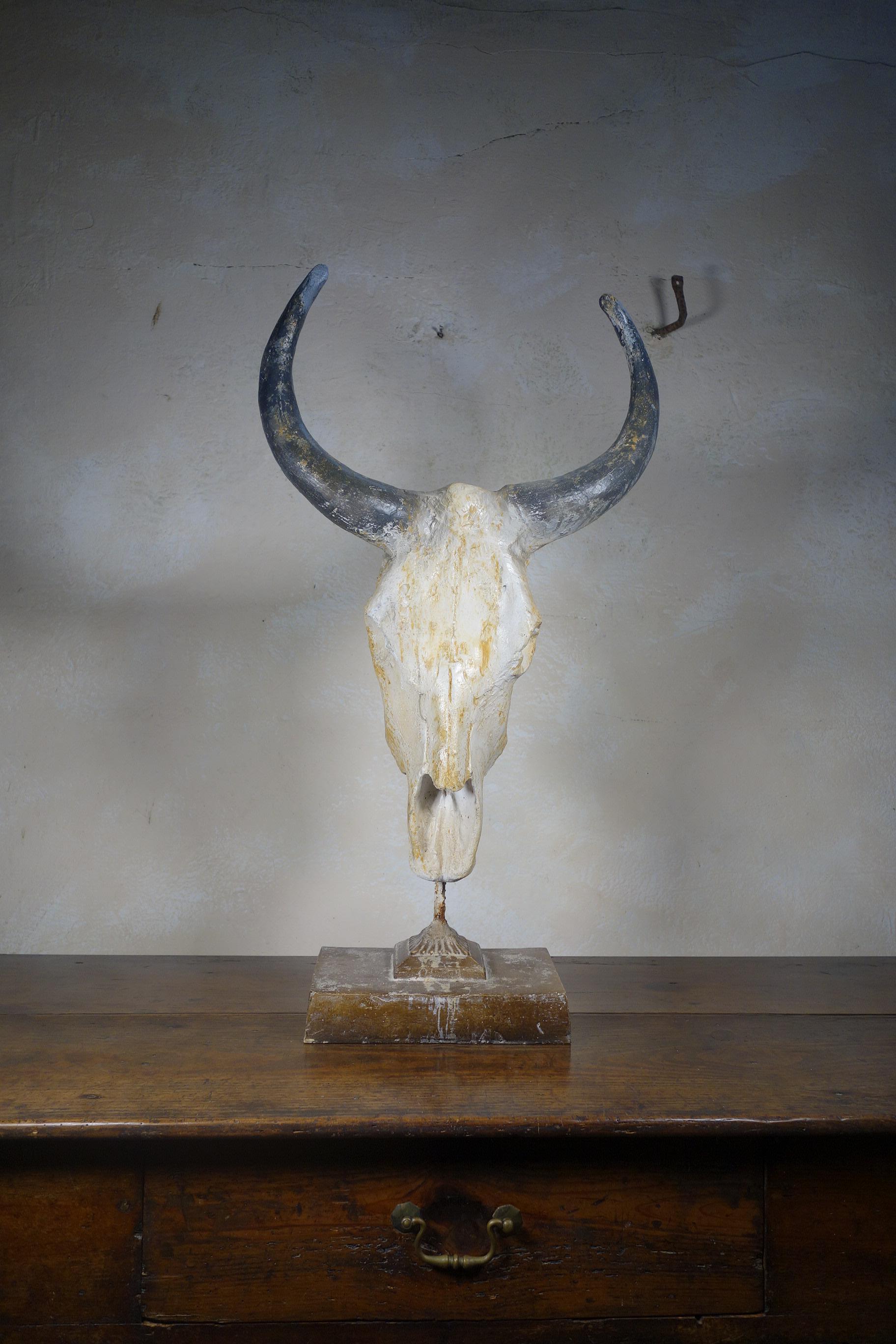 A decorative 20th century faux painted buffalo skull sculpture, raised on a rectangular plinth stand. An extremely well-executed example with detailed painting across the surface to help create the illusion of a real skull, featuring a unique and