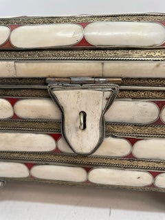 A decorative bone with turquoise and red inlay box. Handles on each side.