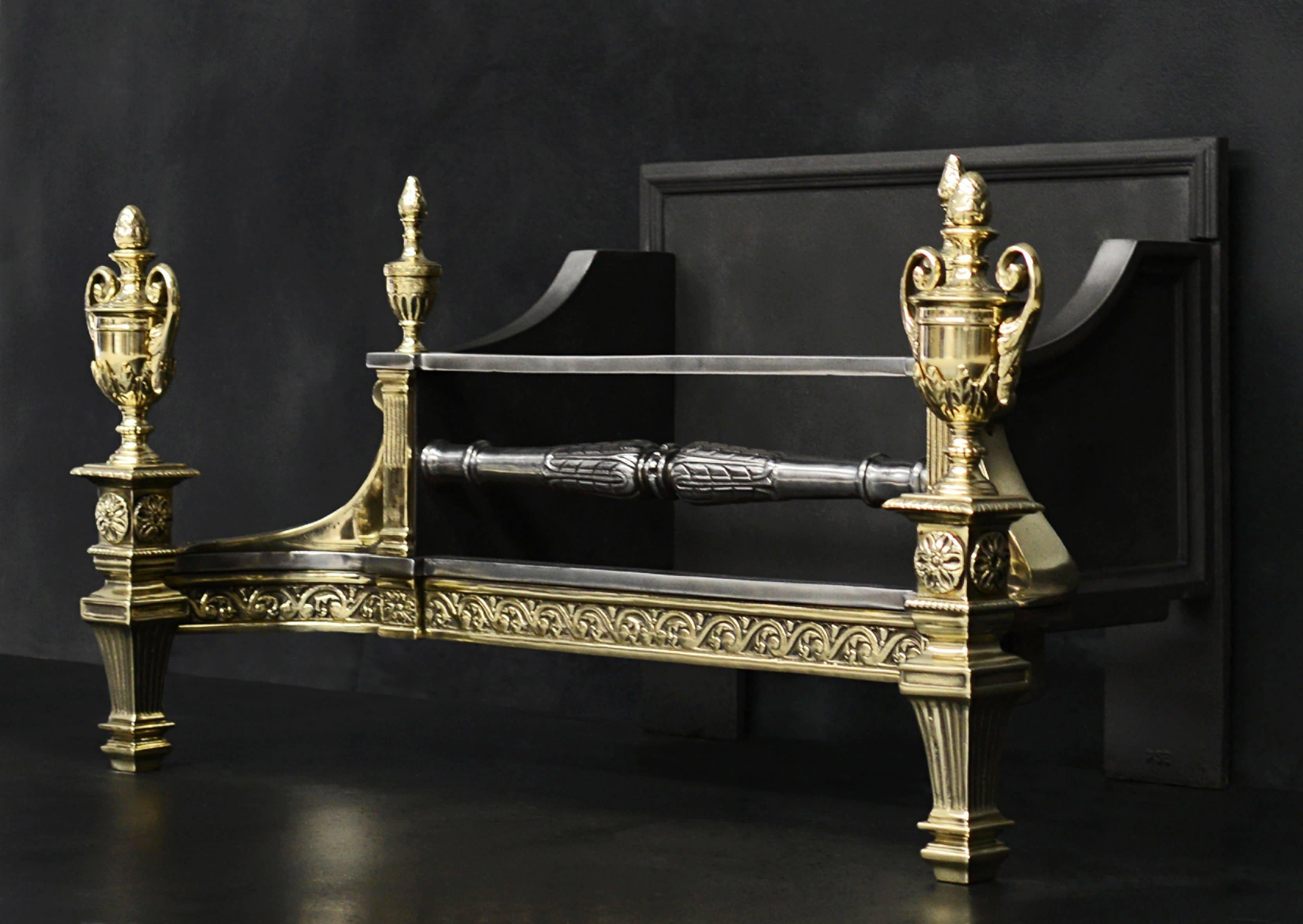A decorative brass and steel firegrate. The tapering legs surmounted by rosette and ornate urn. The fret with scrolls and fluting, surmounted by engraved finials. English, late 19th century.

Measures: Width at front: 890 mm 35