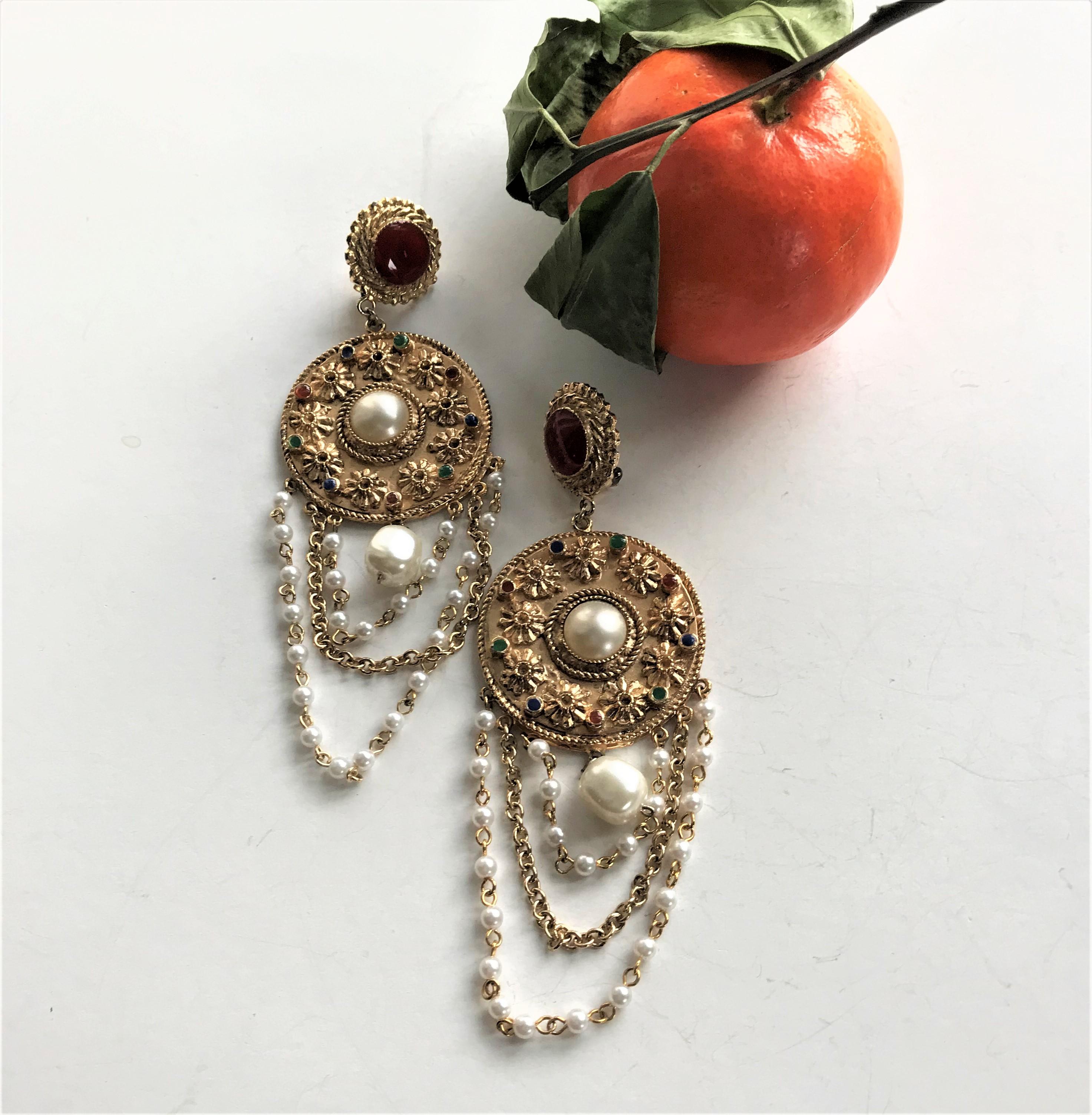 Dimensions: the entire length of the ear clip with the 3 attached chains is 13 cm,
the upper round part with the false carnelian is 2 cm in diameter. The large disc with a false pearl 1.5 cm in the middle 4.5 cm in diameter.
The  3 fine attached