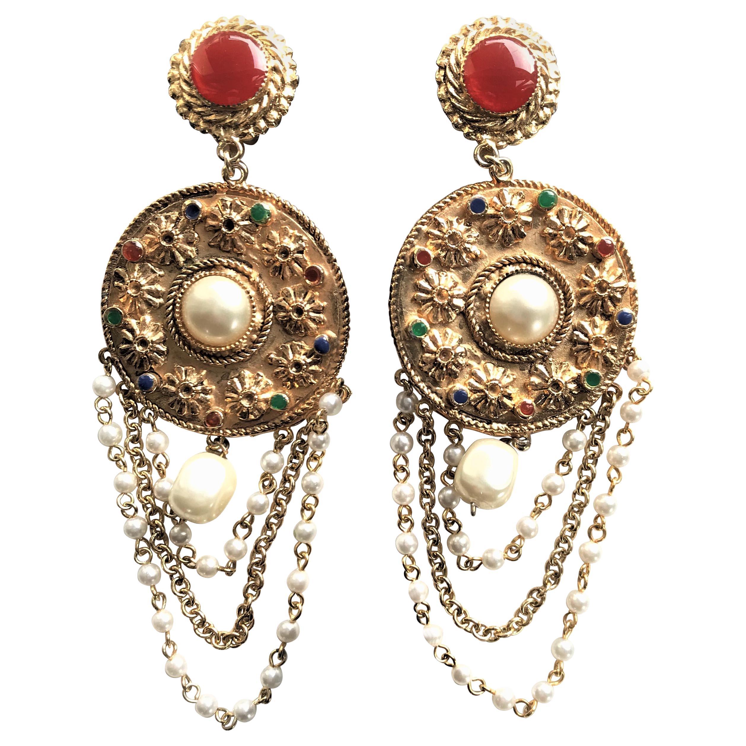  Un clip d'oreille décoratif non signé, plaqué or avec de fausses perles et chaînes, France