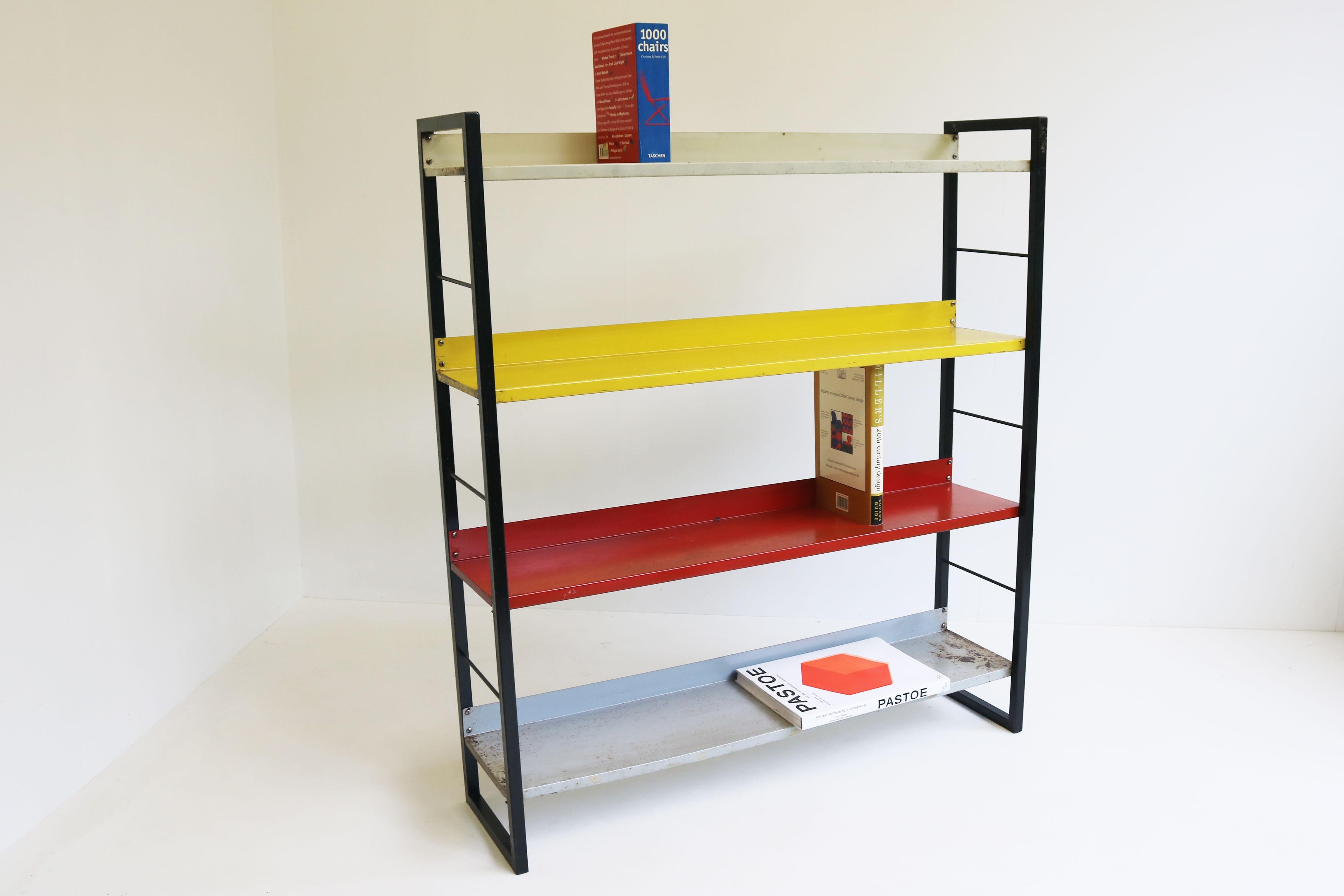 Gorgeous free standing colourfull minimalist bookcase by dutch designer Adriaan Dekker in 1950. 
The bookcase has been worn and heavily used. Some loss of paint and signs of rust. giving the piece a vintage industrial vibe. Would make a great piece
