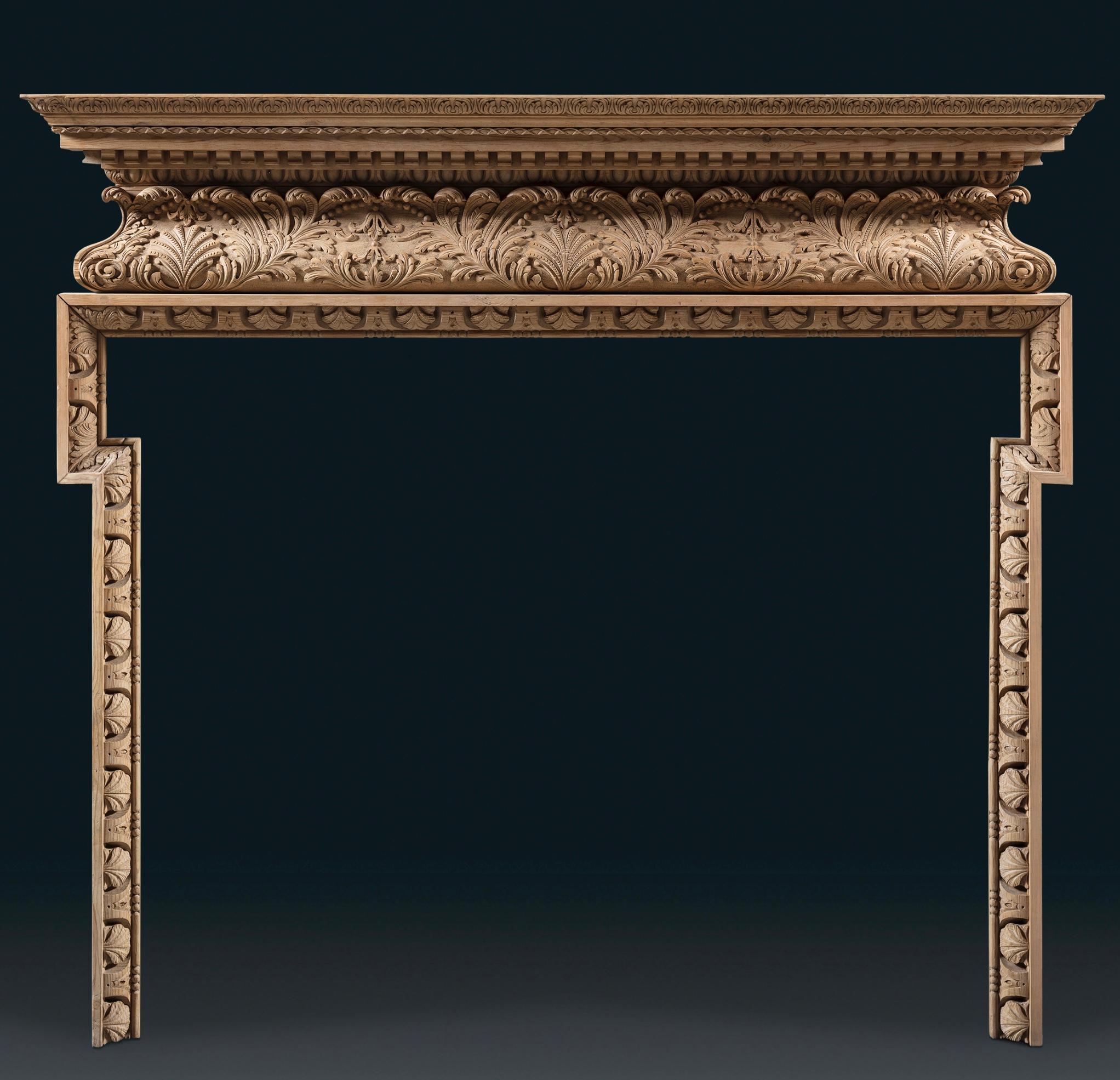 The tiered shelf is punctuated by finely carved dentils, egg and dart, and acanthus ornamental details. This is supported by an elegant acanthus leaf frieze with beading. The slender dog leg jambs, carved with leaf and dart motif and a bead and reel