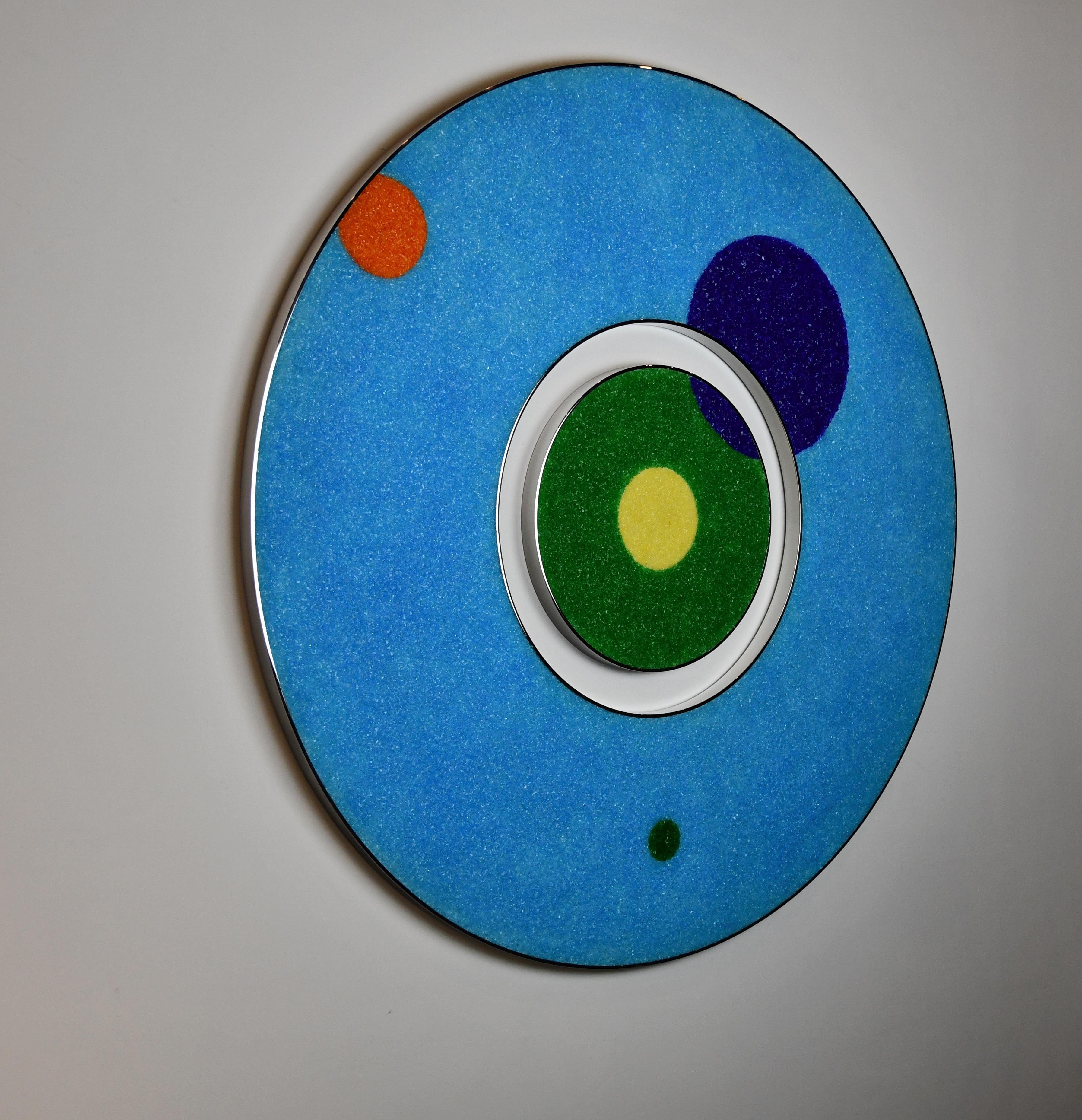 “A Delicate Balance” is a one-of-a-kind two-piece wall sculpture. The outer circle is made with fragmented Murano glass and acrylic over a base of reclaimed wood framed by two thin bands of stainless-steel polished to a mirror finish. The inner