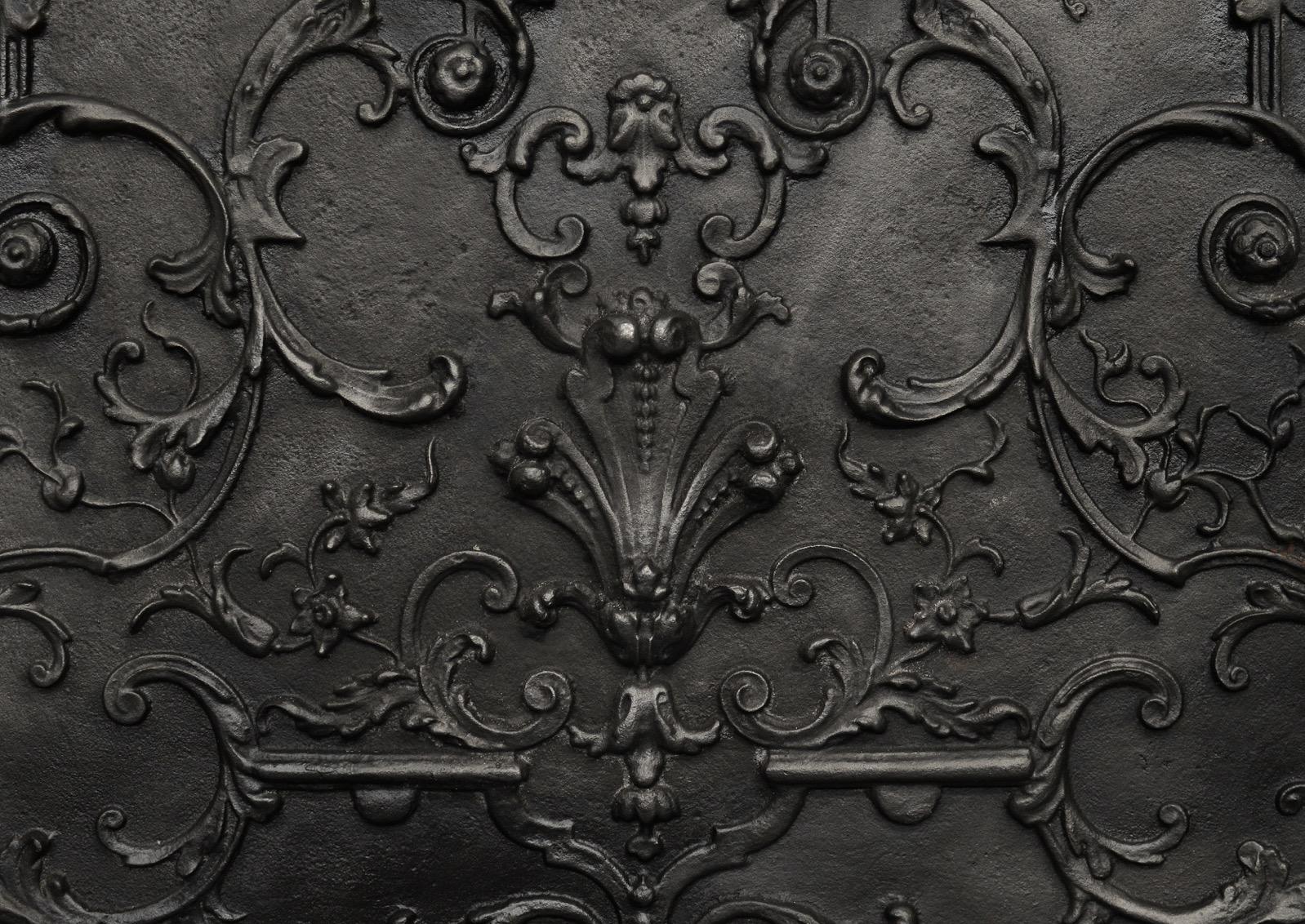 An attractive cast iron fireback. The centre with cast scotia, bell flowers and foliage, flanked by masks. English. (Height could be reduced if required.)

Measures: Height: 700 mm 27 ½