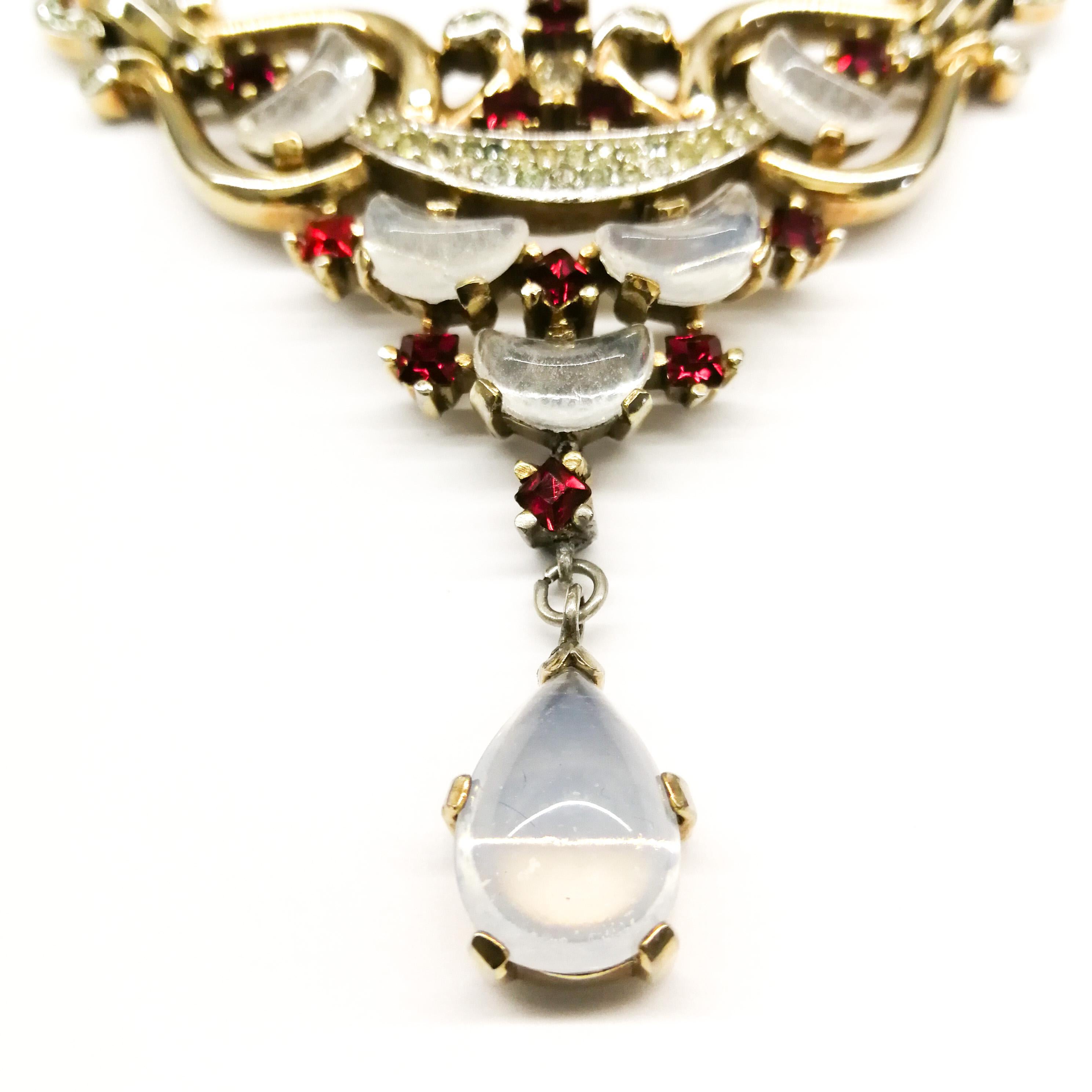 A desirable and wearable necklace, designed by Alfred Philippe for Trifari, as part of the 'Clair De Lune' collection, produced in the early 1950s. Set with 'demi-lune' moonstone glass stones, or crescents, with a drop, and ruby and clear pastes, it