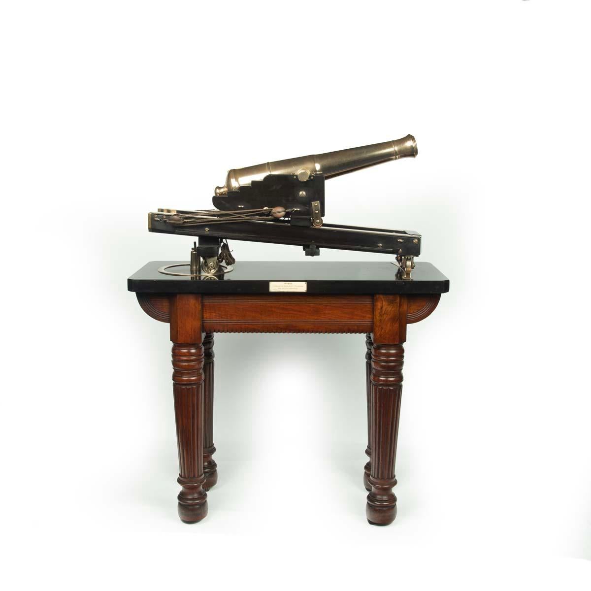A demonstration or museum model of a civil defence traversing cannon. This bronze scale model of a defence cannon rests on a solid ebony carriage with working blocks and tackle to run the barrel out.  It is set on a Derbyshire black marble base