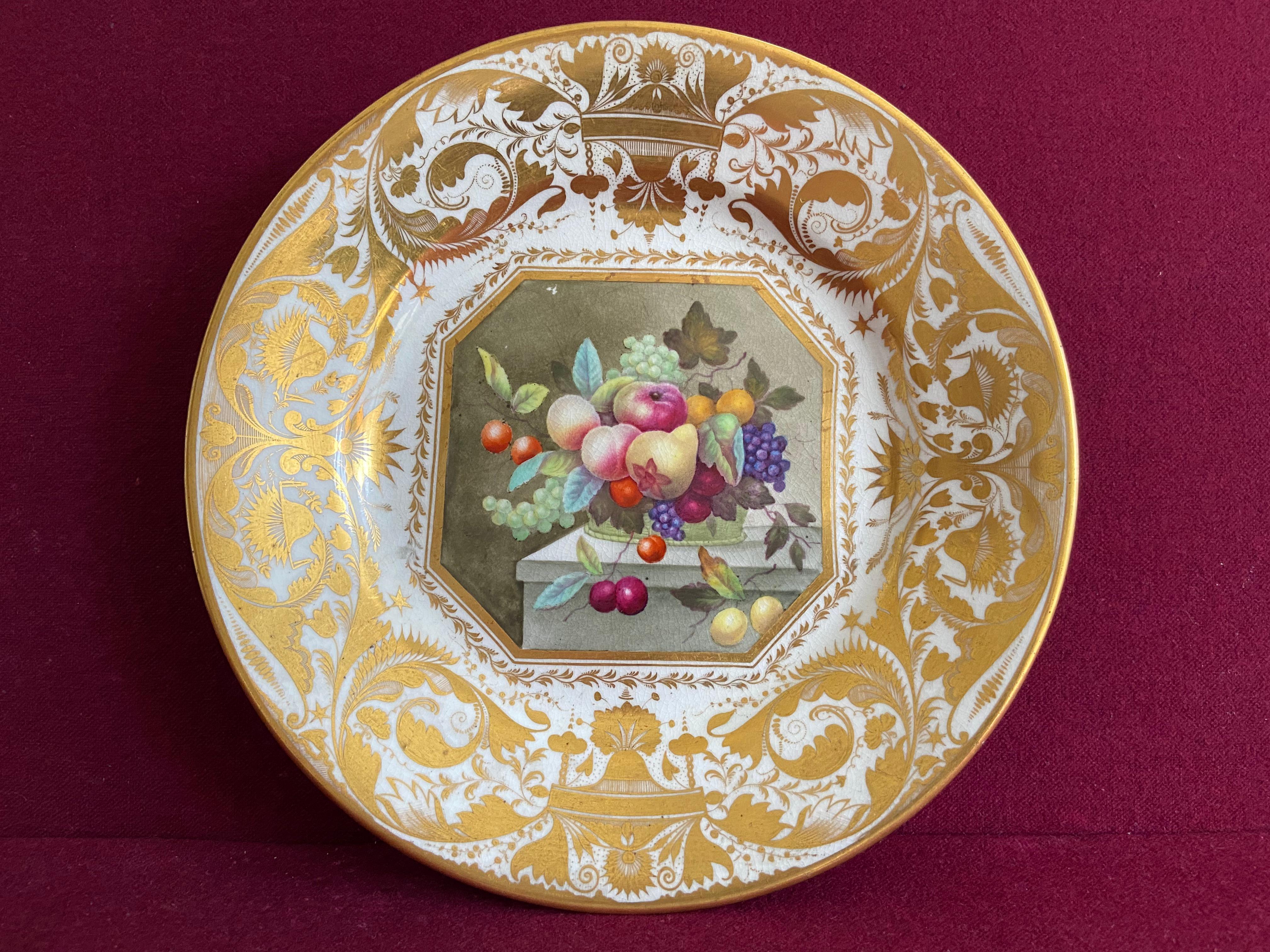 A very fine Derby porcelain dessert plate c.1815. Deecorated by Thomas Steel with a panel of fruits in a wicker basket on top of a marble table. The border decorated with rich elaborate gilding. Crimson Derby mark to the underside of the