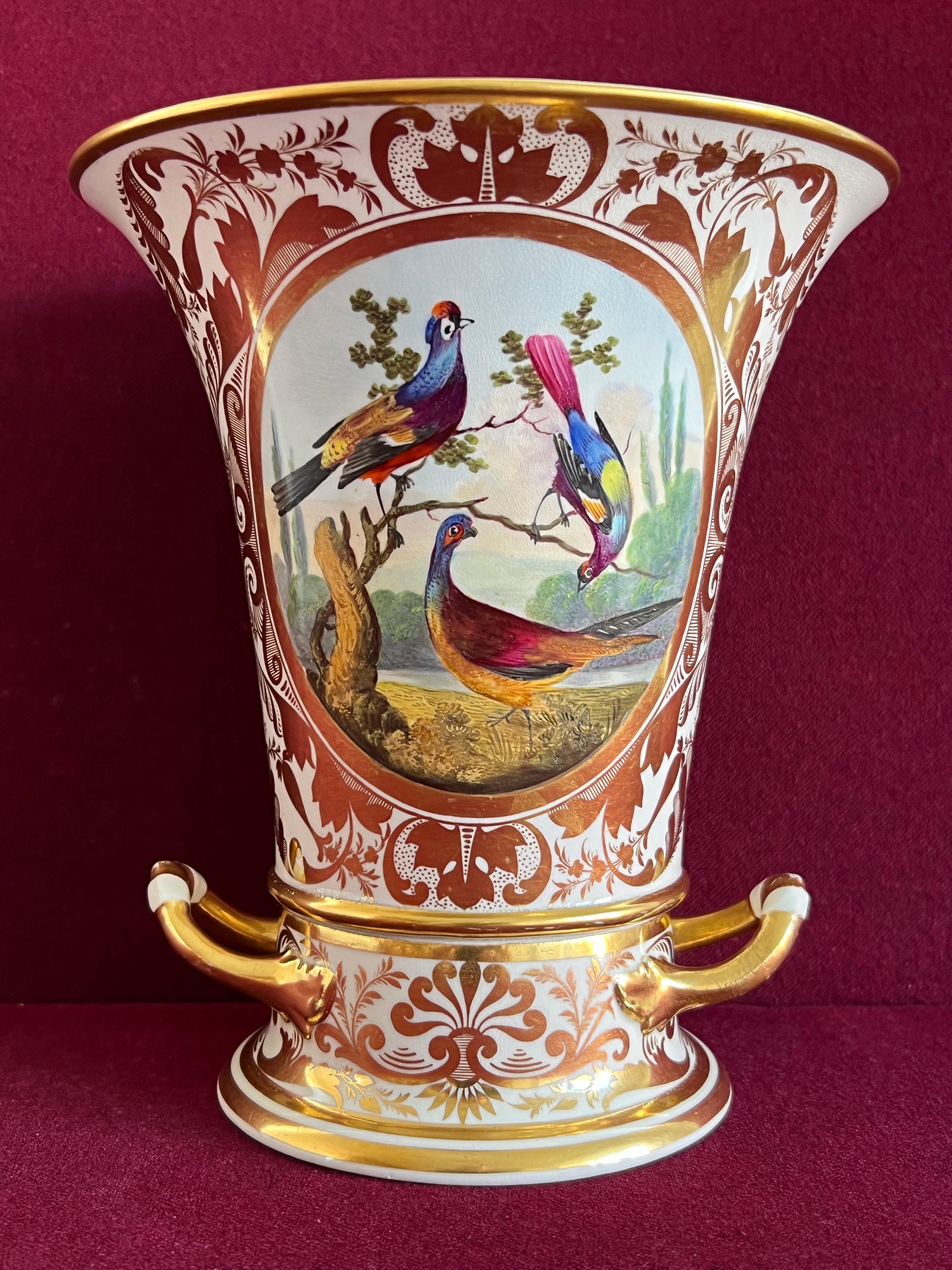 A Derby porcelain two-part vase c.1820. Of elongated campana shape, finely decorated with birds in a landscape by Richard Dodson within an ornately gilded cartouche. Crimson crown over crossed swords and the letter D mark to the base. 

Condition: