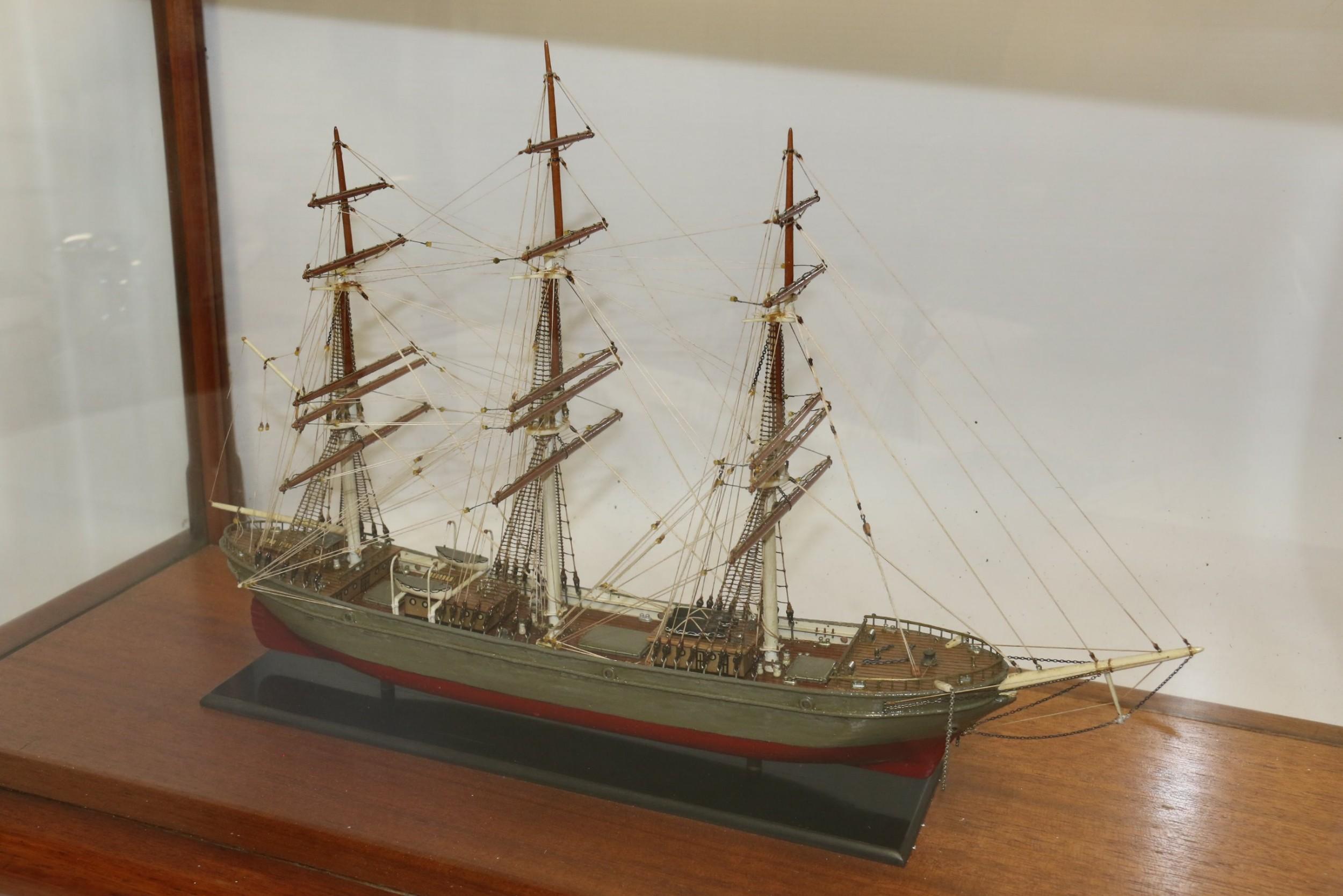 This scratch built scale model of an early 19th century three mast ship has been painstakingly built with great detail to the deck and rigging. It has a hand painted finish in red and grey and has been mounted in a bespoke period mahogany glazed