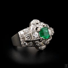 A diamond and platinum ring, set with a rectangular shaped emerald