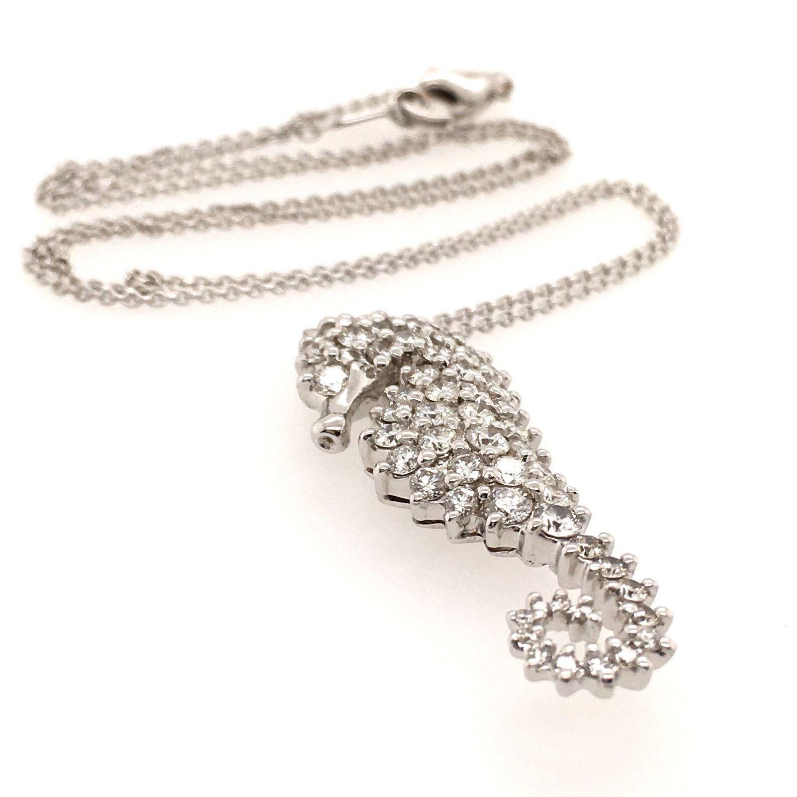 An 18 karat white gold and diamond sea horse pendant necklace. Suspending a pave set diamond sea horse, set with fifty (50) diamonds, weighing approximately 1.70 carat, from a fine link chain. Pendant length is approximately 1 1/4 inches, chain
