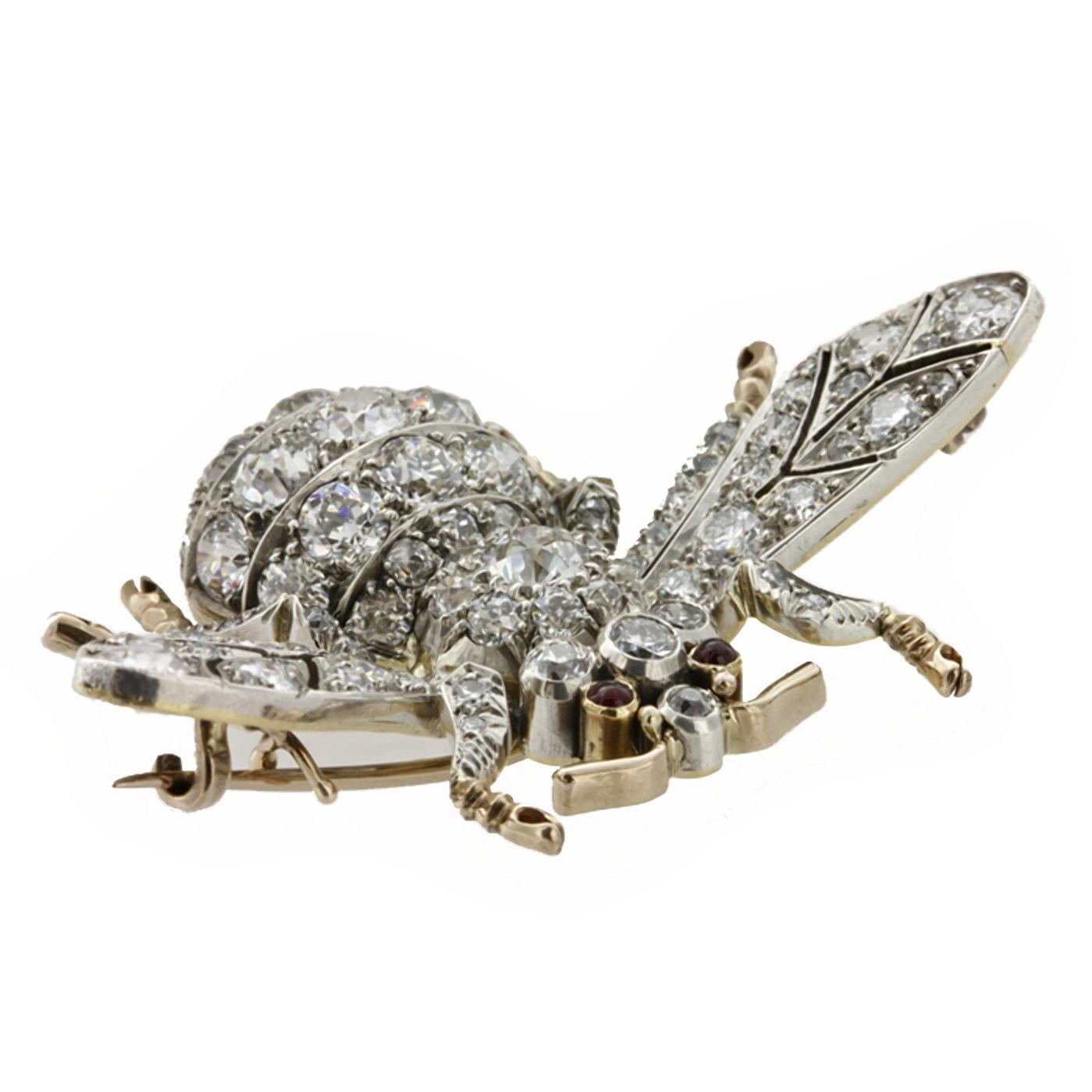 A diamond bee brooch, in the form of a bumble bee in flight, the delicately veined wings, domed body and thorax and outstretched legs encrusted with graduated old brilliant-cut diamonds, weighing a total of 9.45 carat, with ruby cabochon eyes, all