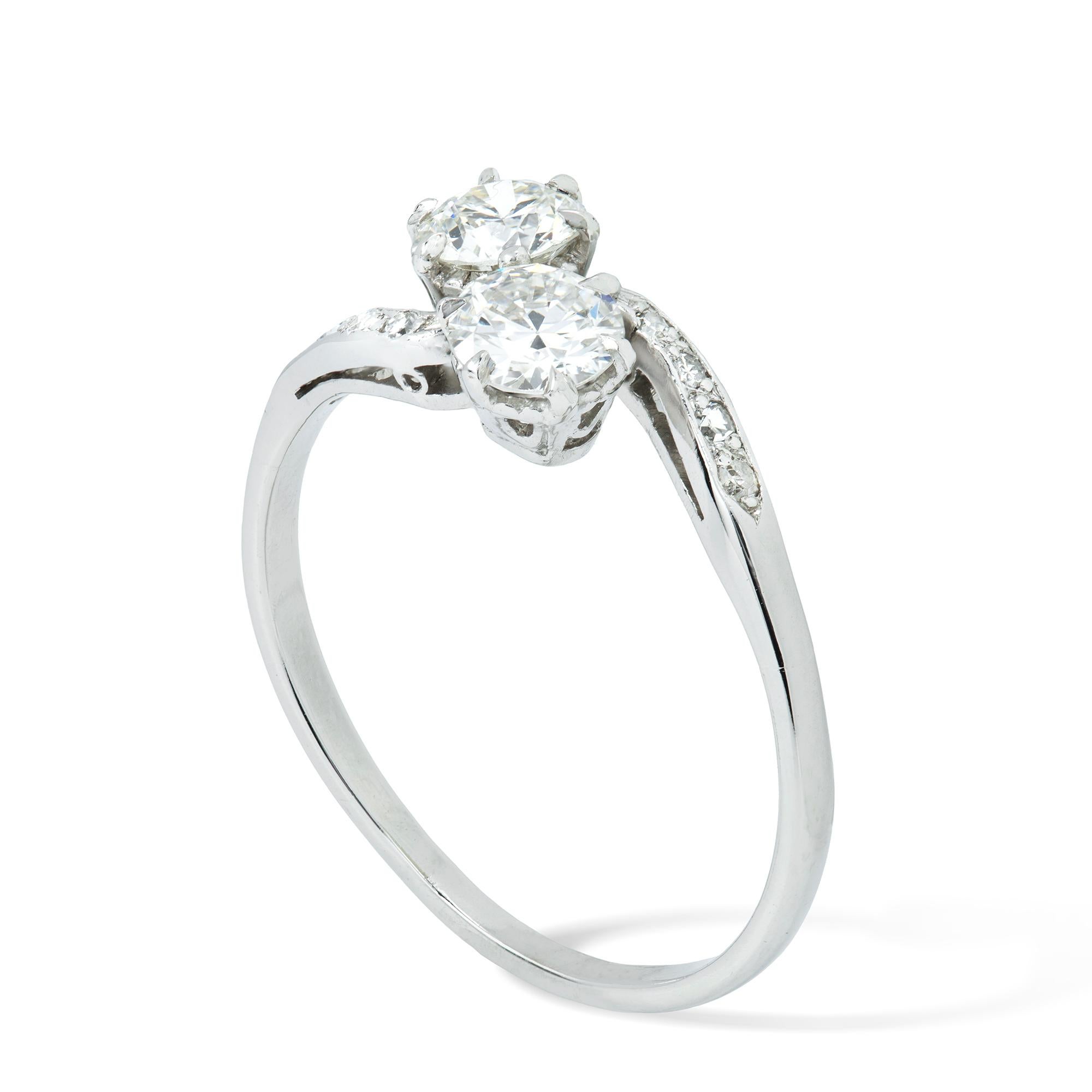 Bague croisée en diamant, les deux diamants ronds pesant 0,80 carats au total, sertis en croix avec des épaules courbes serties de diamants, le tout serti en platine, vers 1920, poinçonné plus tard platine 950, Londres, la tête mesurant 0,7x1,6 cm,