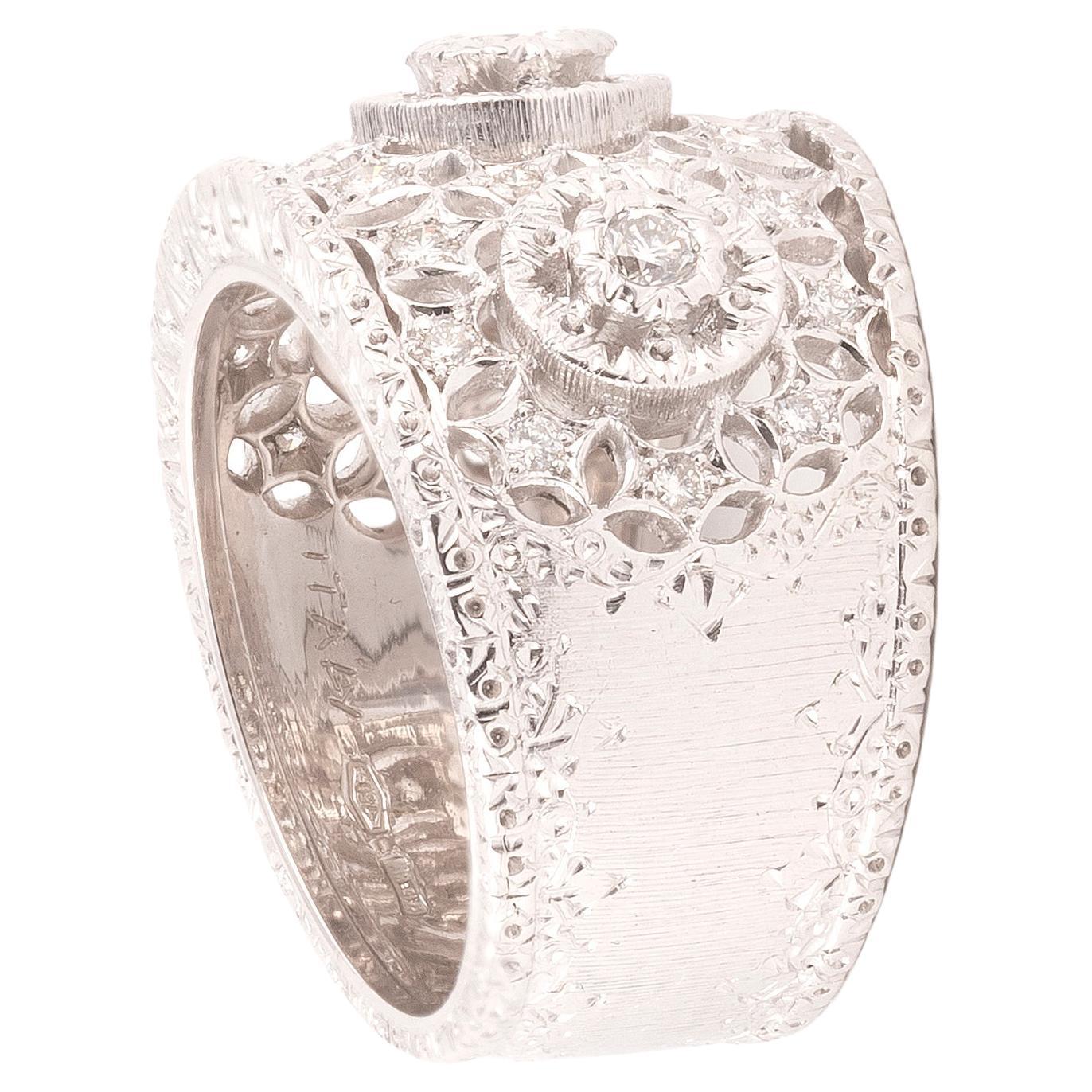 Openwork band design white gold and diamond ring, centering a round brilliant-cut diamond accented by smaller round brilliant diamonds.
Weight : 11.83gr.
Size 7. 
Signed and marked M. Buccellati, 15 MI.
