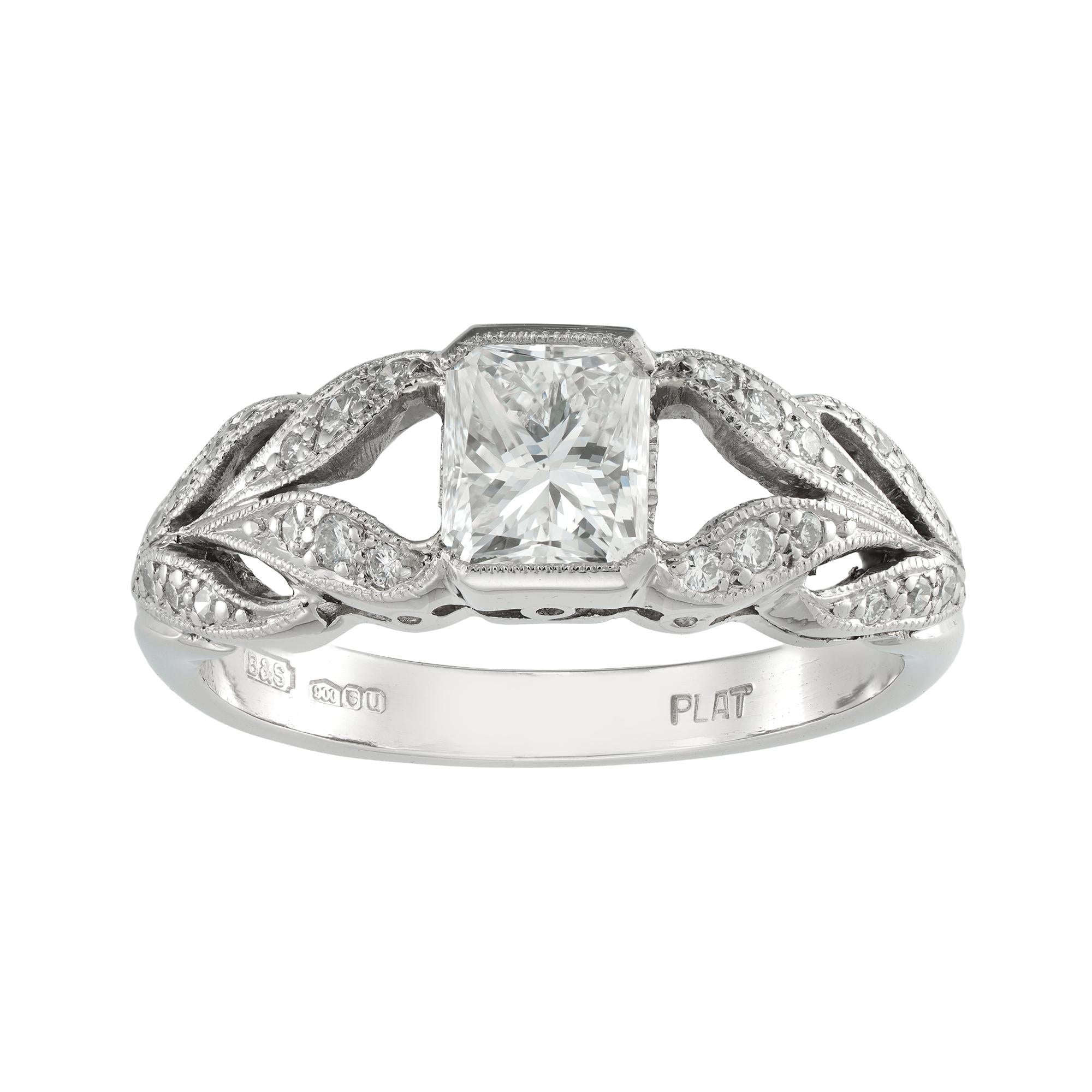 A diamond engagement ring, the radiant-cut diamond weighing 0.71 carats accompanied by De Beers report stating to be of G colour and VS2 clarity, half rub-over set between laurel-leaf designed shoulders millegrain-set with small round brilliant-cut