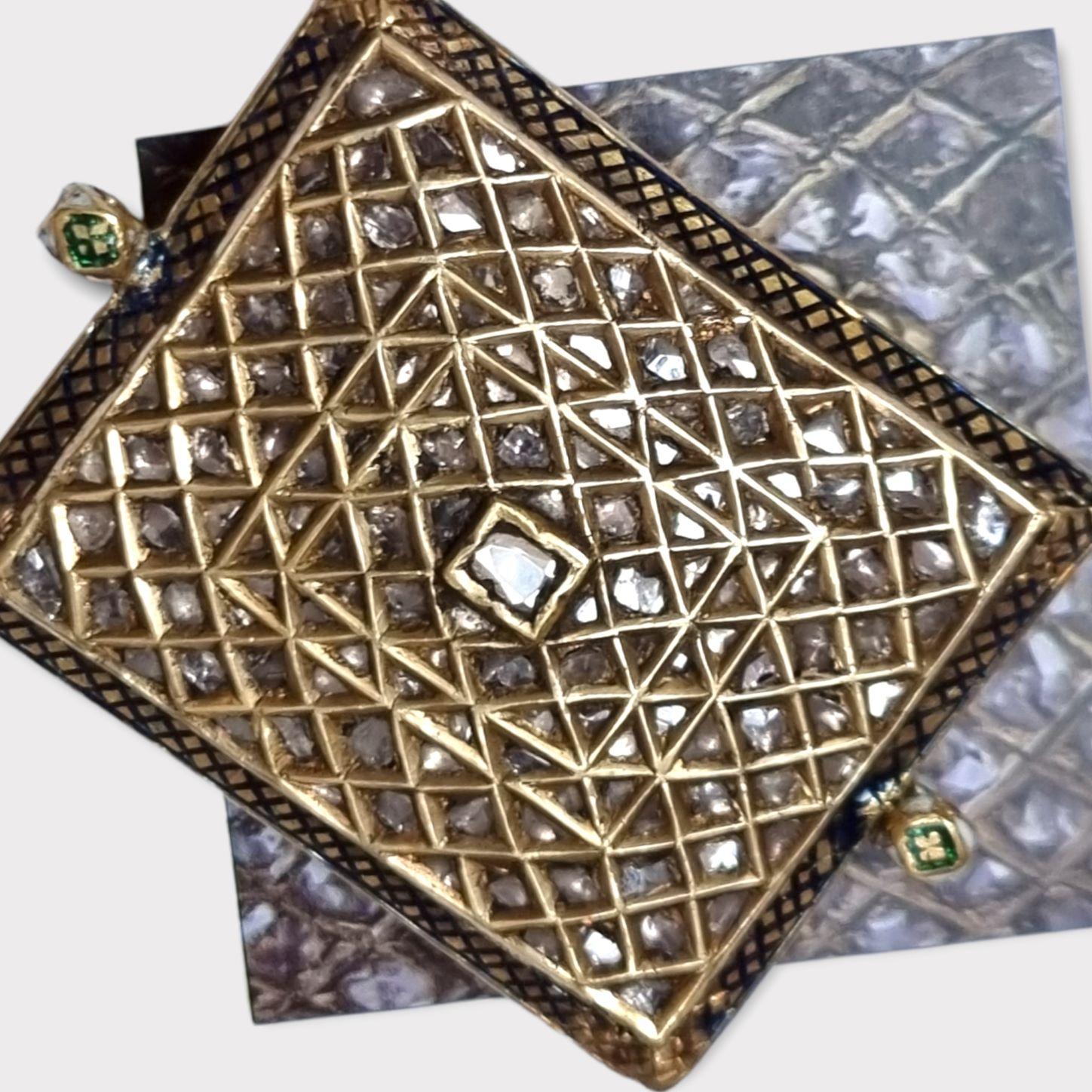 A DIAMOND-SET ENAMELLED GOLD BAZUBAND (Armband)
NORTH INDIA, 19TH CENTURY
Rectangular with cushion base and two suspension loops, the top set with diamonds in concentric bands, the outer border with navy blue enamel criss-cross design, verso