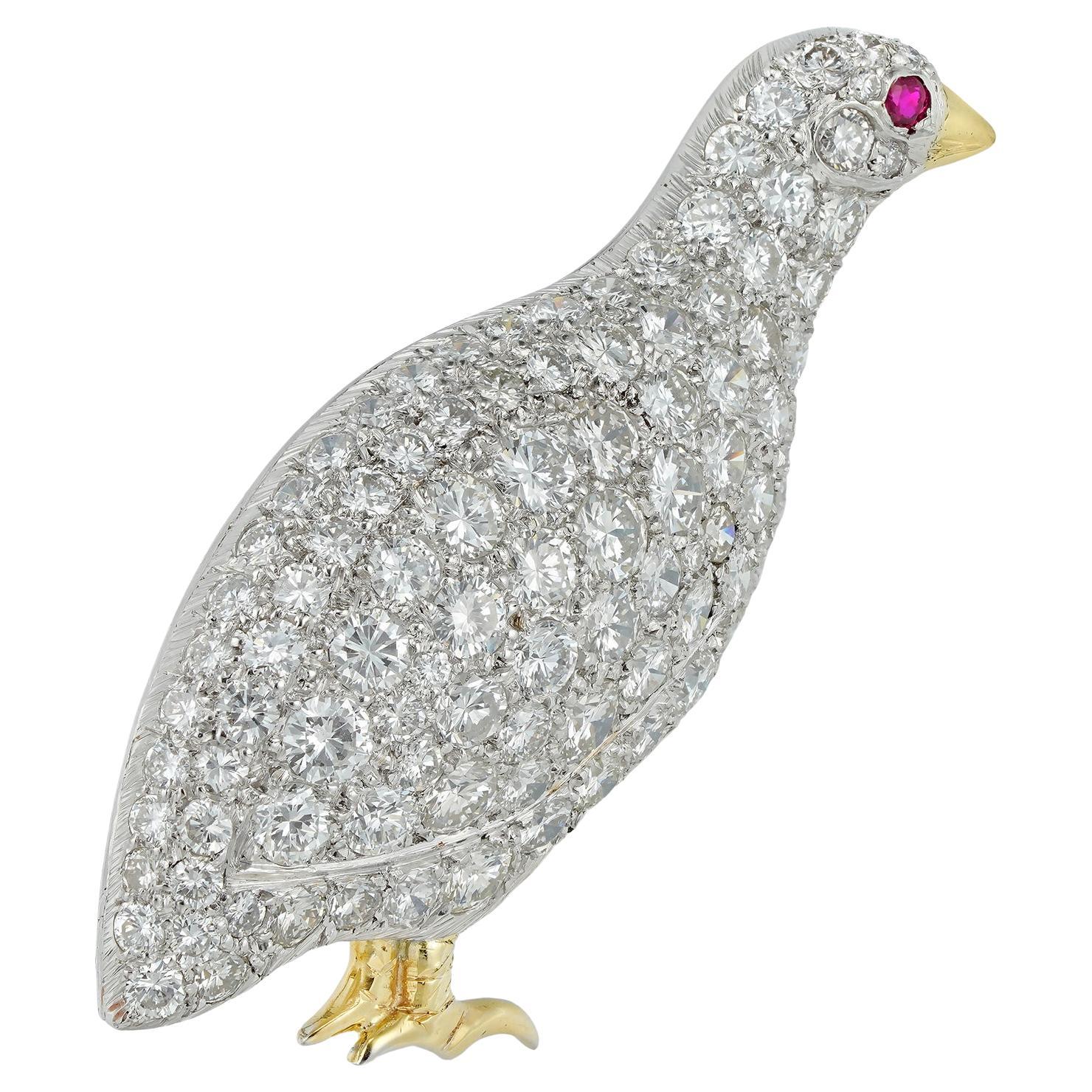 A diamond-set partridge brooch, the body pave-set with round brilliant-cut diamonds estimated to weigh approximately 5 carats in total and a round faceted ruby-set eye, the beak and feet gold gilded, with a gold brooch fitting, hallmarked 950