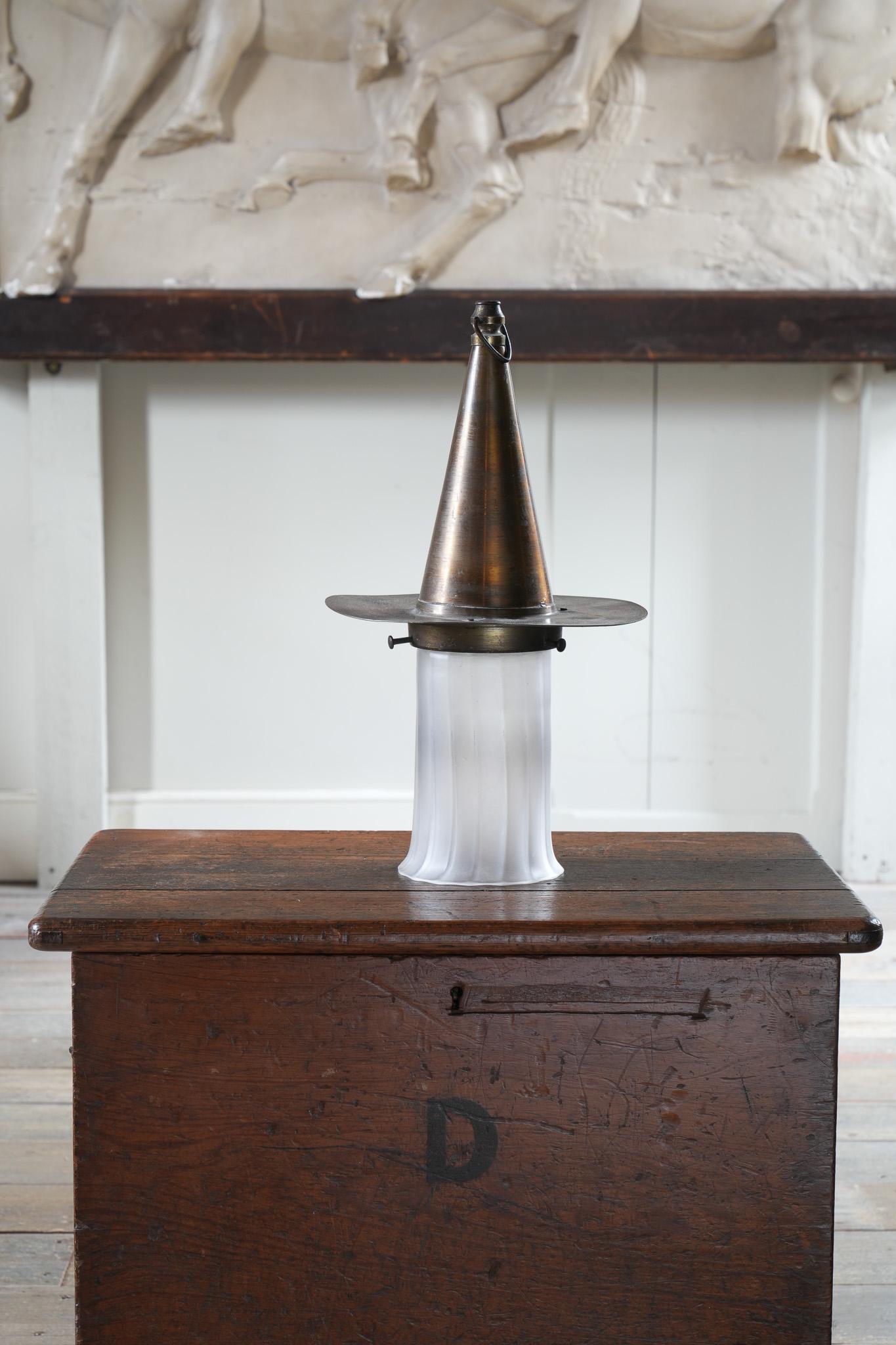 The patinated brass “Witches Hat” supporting a reeded and acid etched shade.