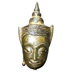 Diminutiva testa di Buddha incoronato in lega di rame dorato, periodo Ayutthaya