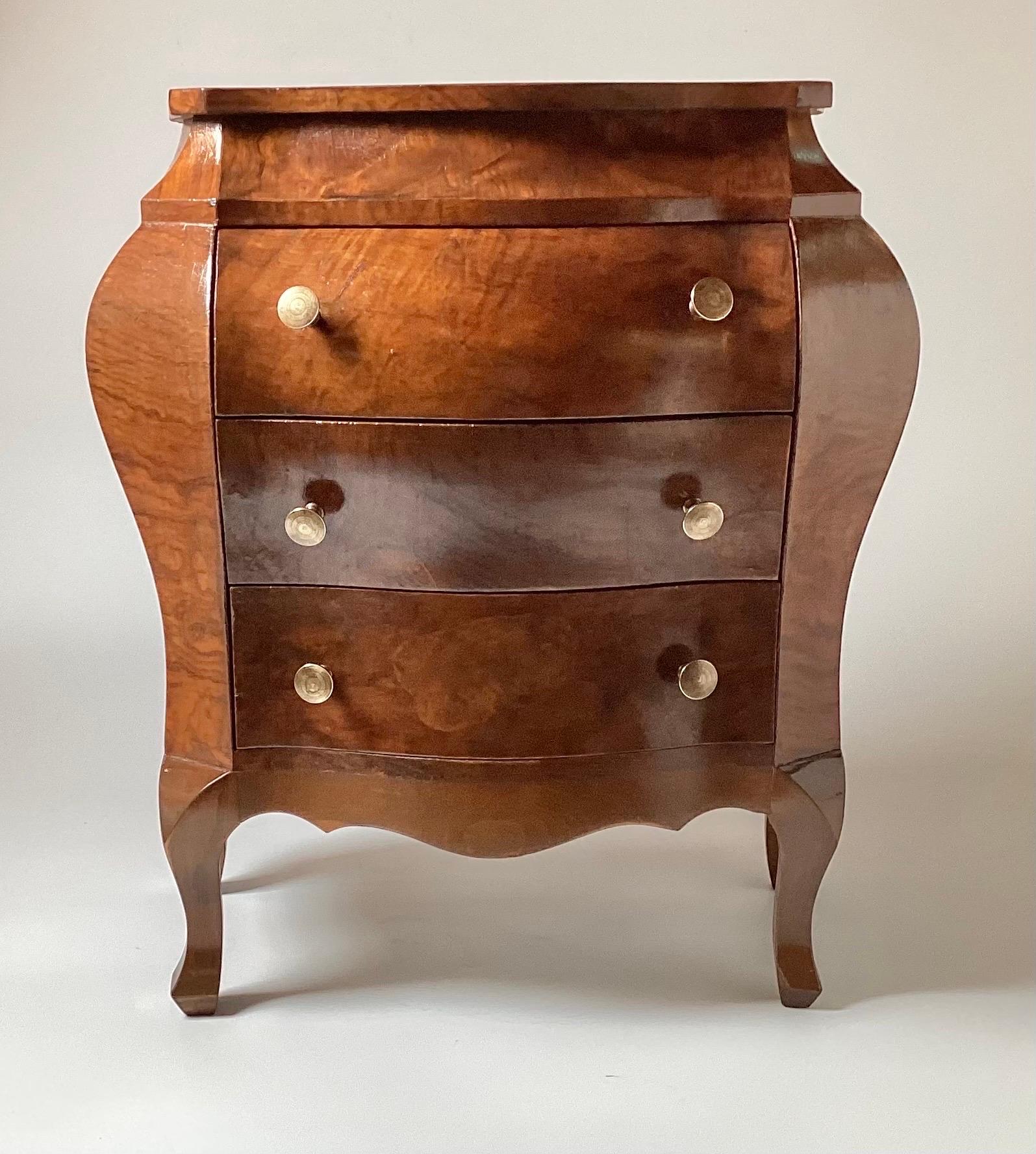 A diminutive walnut bombe chest made in Italy, mid 20th century. The figurative grain with three shapely drawers and brass handles with a recent French Polish. Perfect accent piece 20.5 inches tall, 18 inches wide, 10 inches deep.