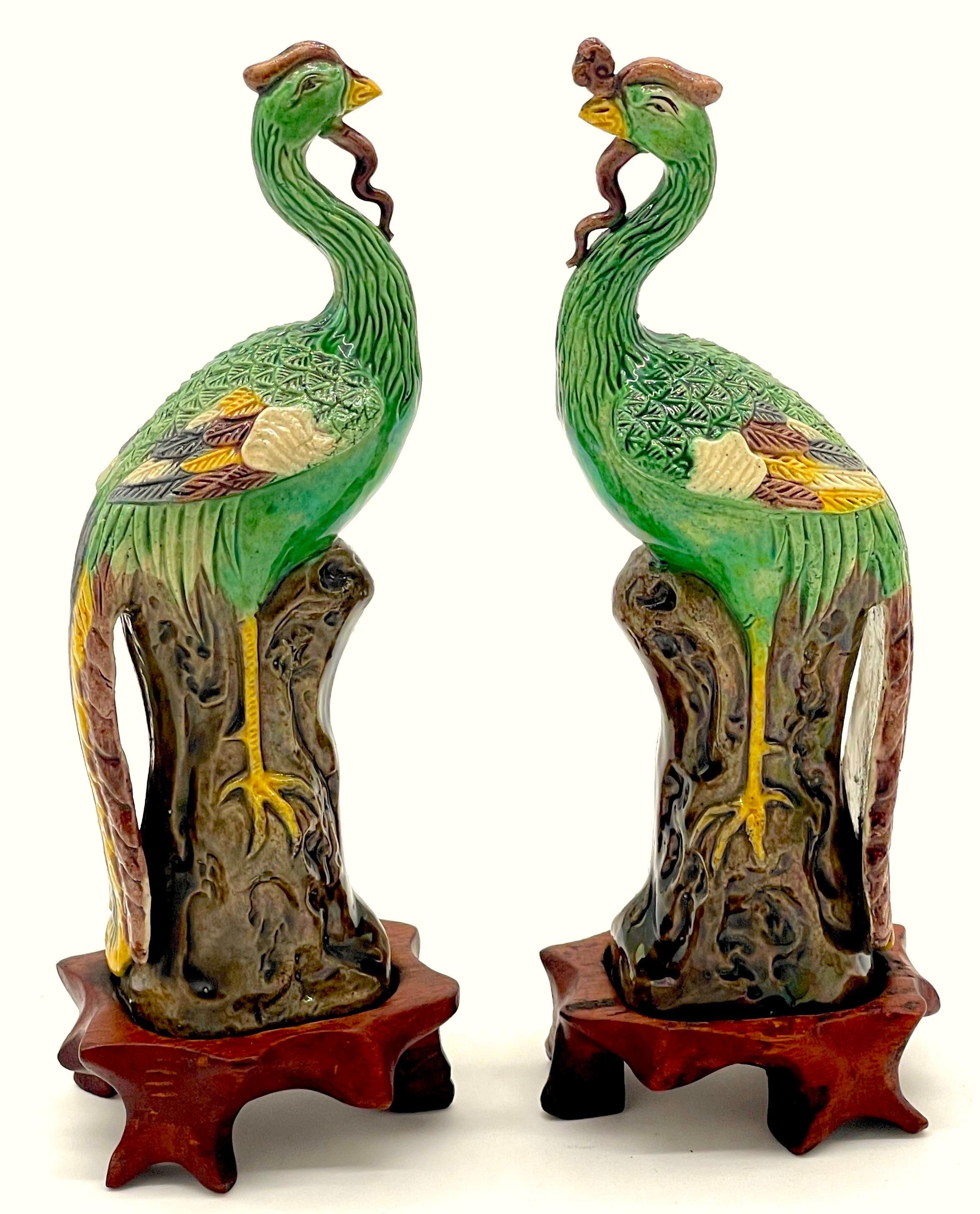 A Diminutive Pair of Chinese Sancai Glazed Phoenix Birds, on Hardwood Stands 
China, 20th Century 
 
A Diminutive pair of Chinese sancai glazed phoenix birds, well presented on carved hardwood stands. These exquisite Fenghuang (Phoenix) bird figures