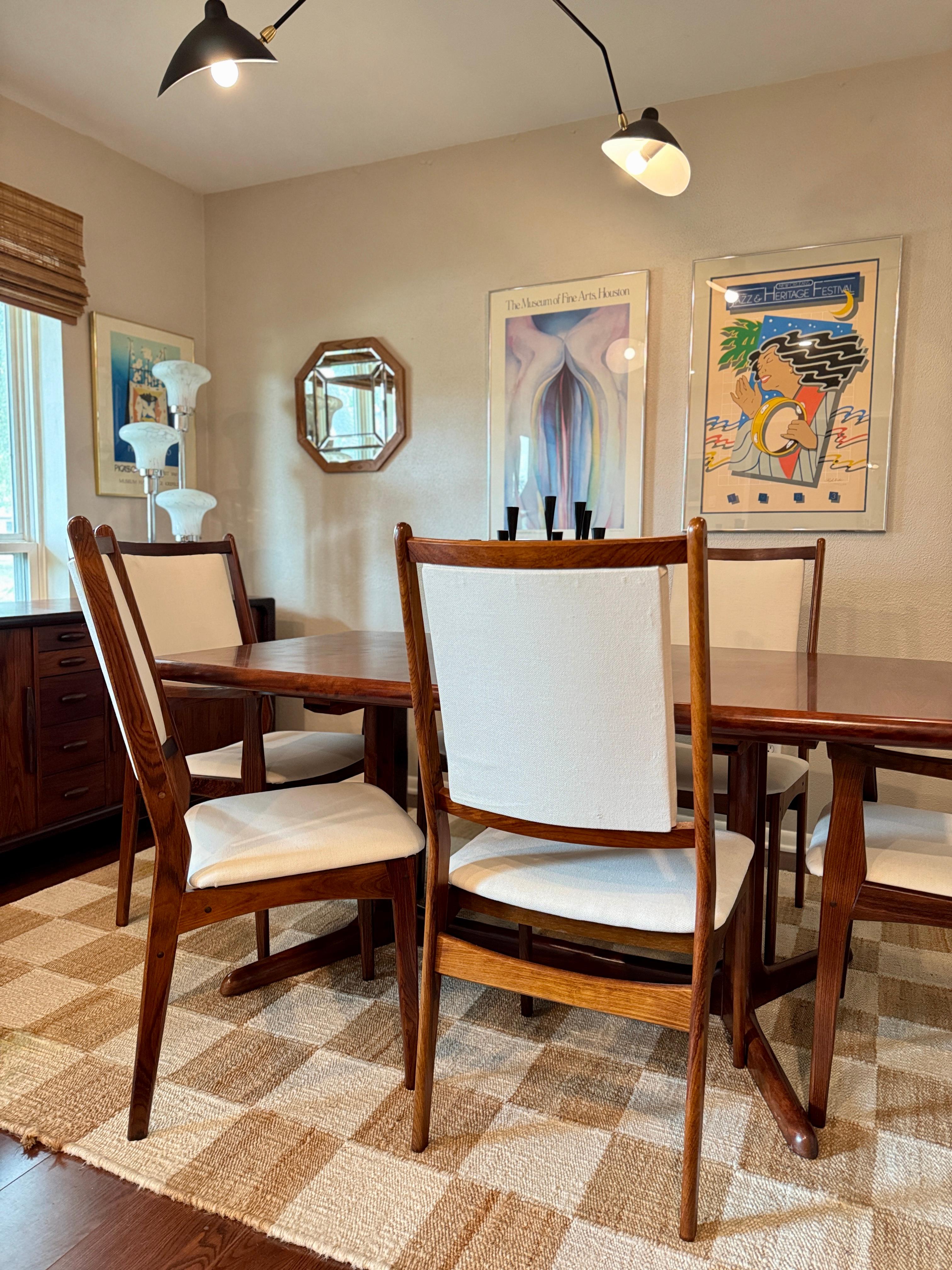 A gorgeous dining set made of Brazilian rosewood by Dyrlund in Denmark, circa 1960s. Includes 6 chairs recently reupholstered in an ivory performance fabric, and a table that includes 2 leaves and expands to seat a large party of up to 10