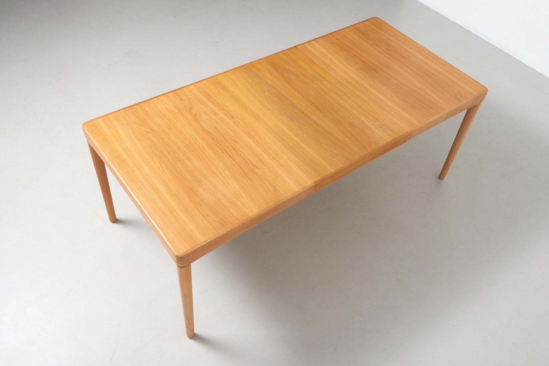 An elegant dining table in oak with 1 extension leaf of 60cm. When the extension is not being used, it can be stored inside the table. When in use, it follows beautifully the lines of the table. The corners feature three stripes, a signature of the