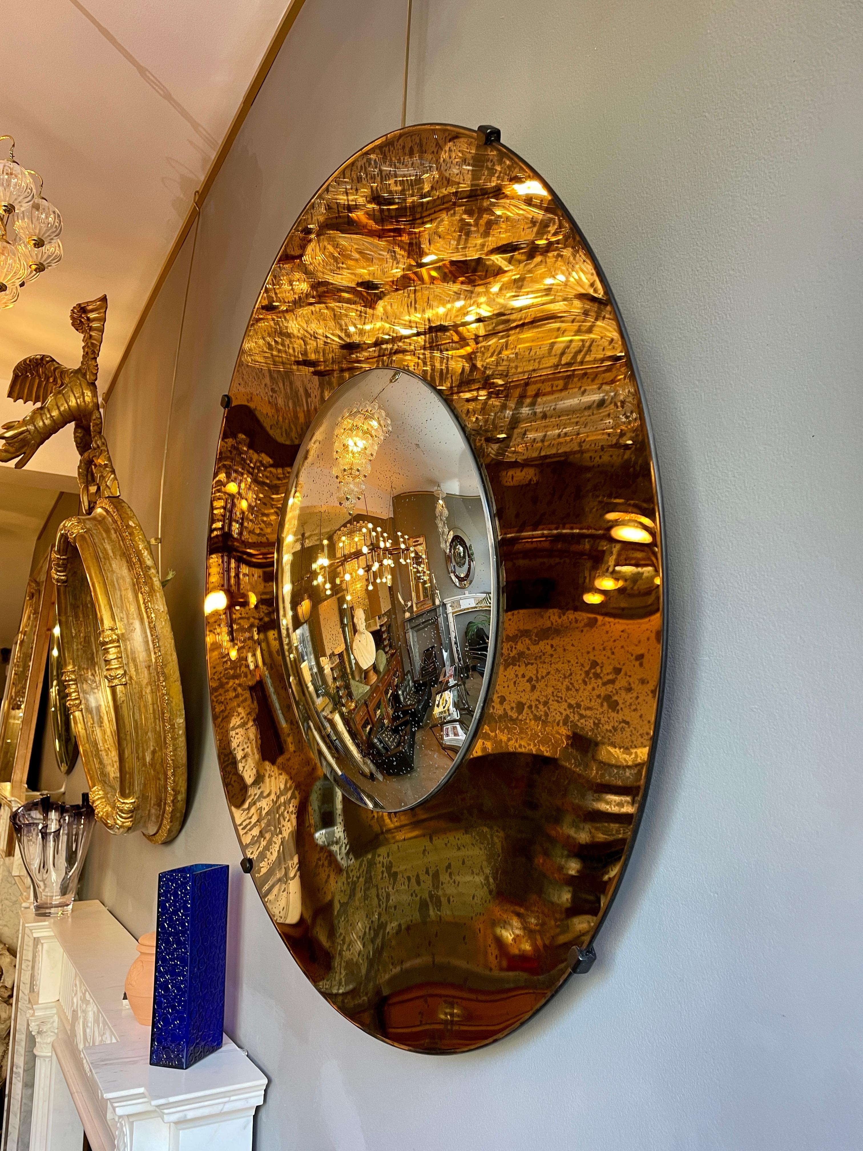 A concave mirror in distressed bronze colour with a silver distressed convex mirror to centre. Frameless, held in place by 4 clips and secured at he back with a circular fitting and built in hook for hanging.