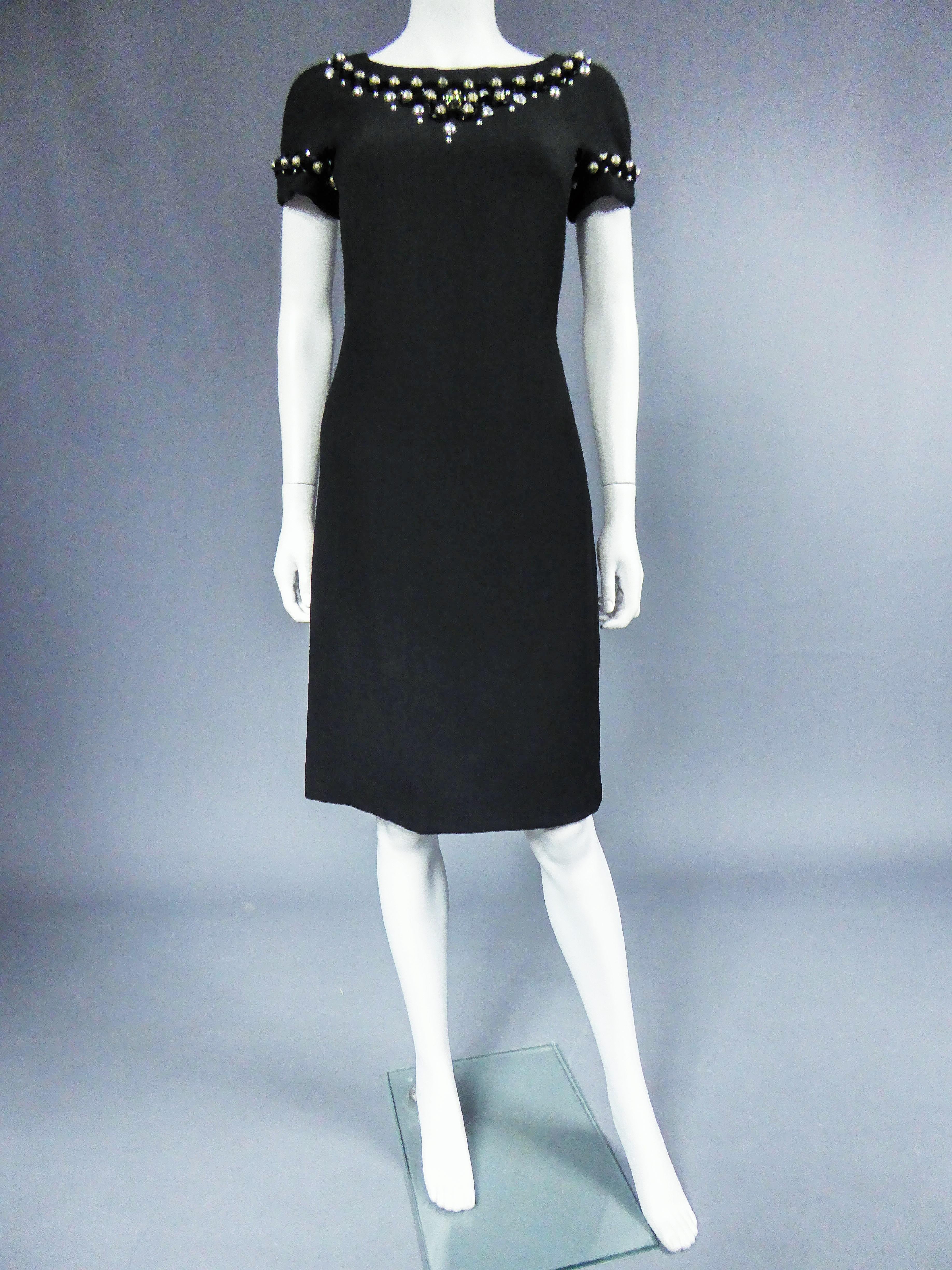 Ungefähr 2005
Frankreich

Kleines schwarzes Kleid mit Bootsausschnitt, appliziert von Schmuck des Mailänder Designers Dolce Gabbana und aus dem Jahr 2000/2010. Schwarzes Trikot aus Stretch. Ausschnitt und kurze Ärmel sind mit Cabochons und