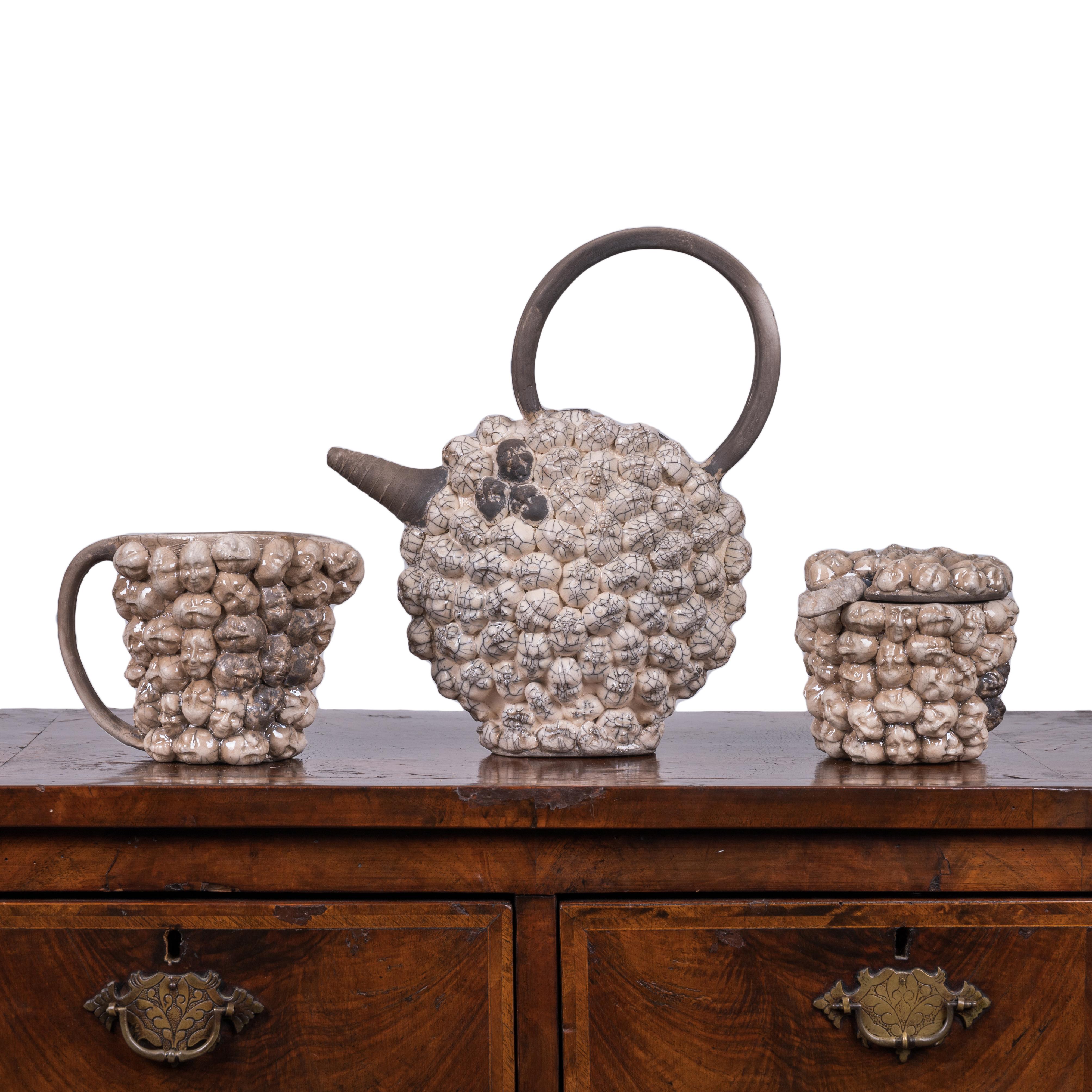Ein Puppenkopf Raku Studio Keramik Tee-Set, unsigniert.

Teekanne: 10 Zoll breit, 4 ½ Zoll tief und 11 ½ Zoll hoch

Zucker und Sahne: ungefähr 7 Zoll breit und 5 Zoll hoch.






