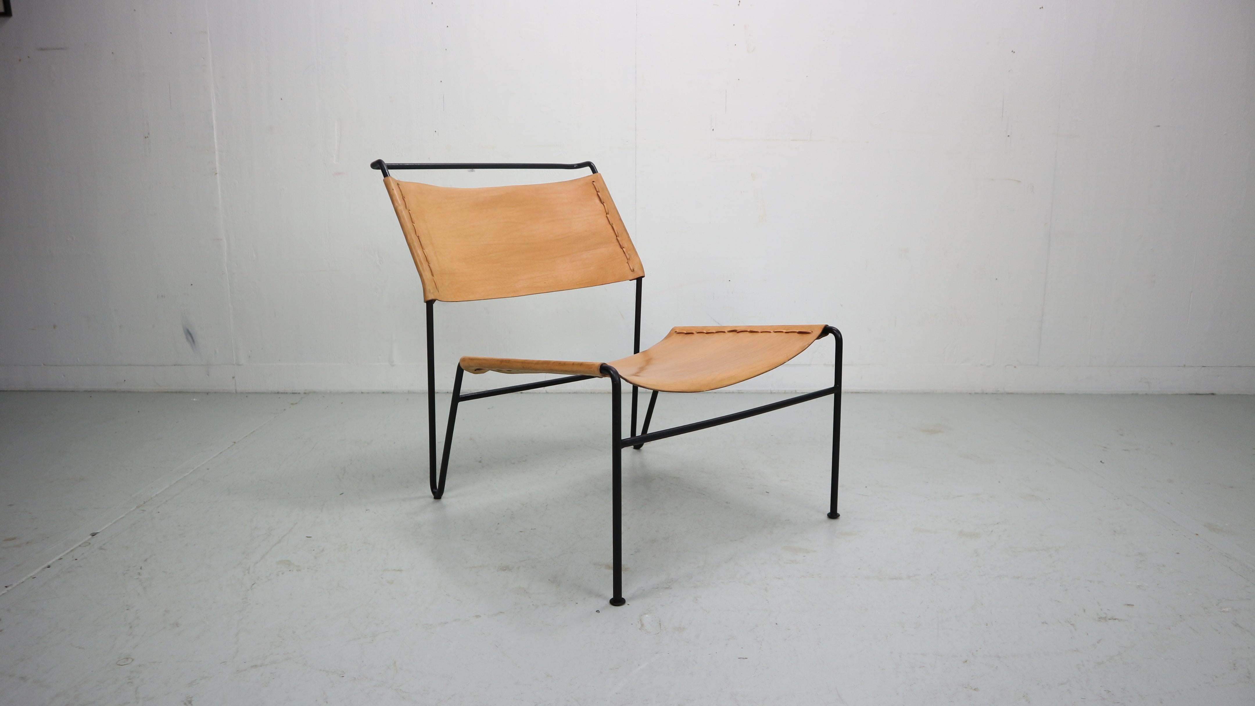 A fantastic  lounge chair designed by A. Dolleman, manufactured by Metz & Co in the Netherlands around 1950. The chair has a very appealing, minimalist design. The thin black lacquered metal bases is nicely bent into shape. The seat and backrest is