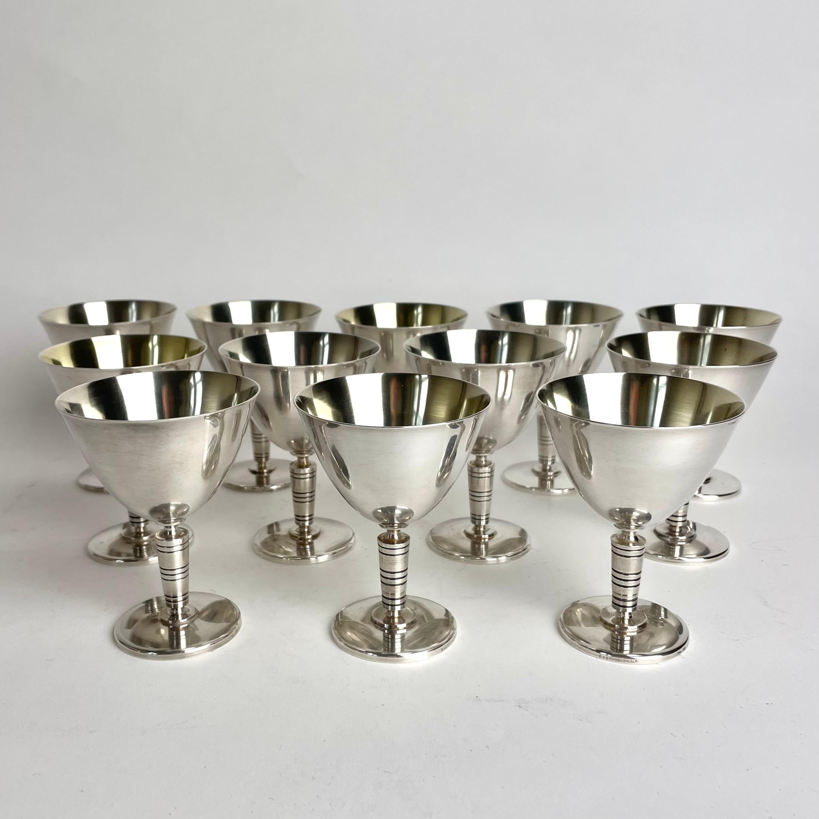 Une douzaine de verres à cocktail Art déco en métal argenté des années 1930 provenant de GAB, Guldsmedsaktiebolaget en Suède. Un design très ancien. L'intérieur des bols en verre présente des traces d'usure de la dorure.

Usure conforme à l'âge et à