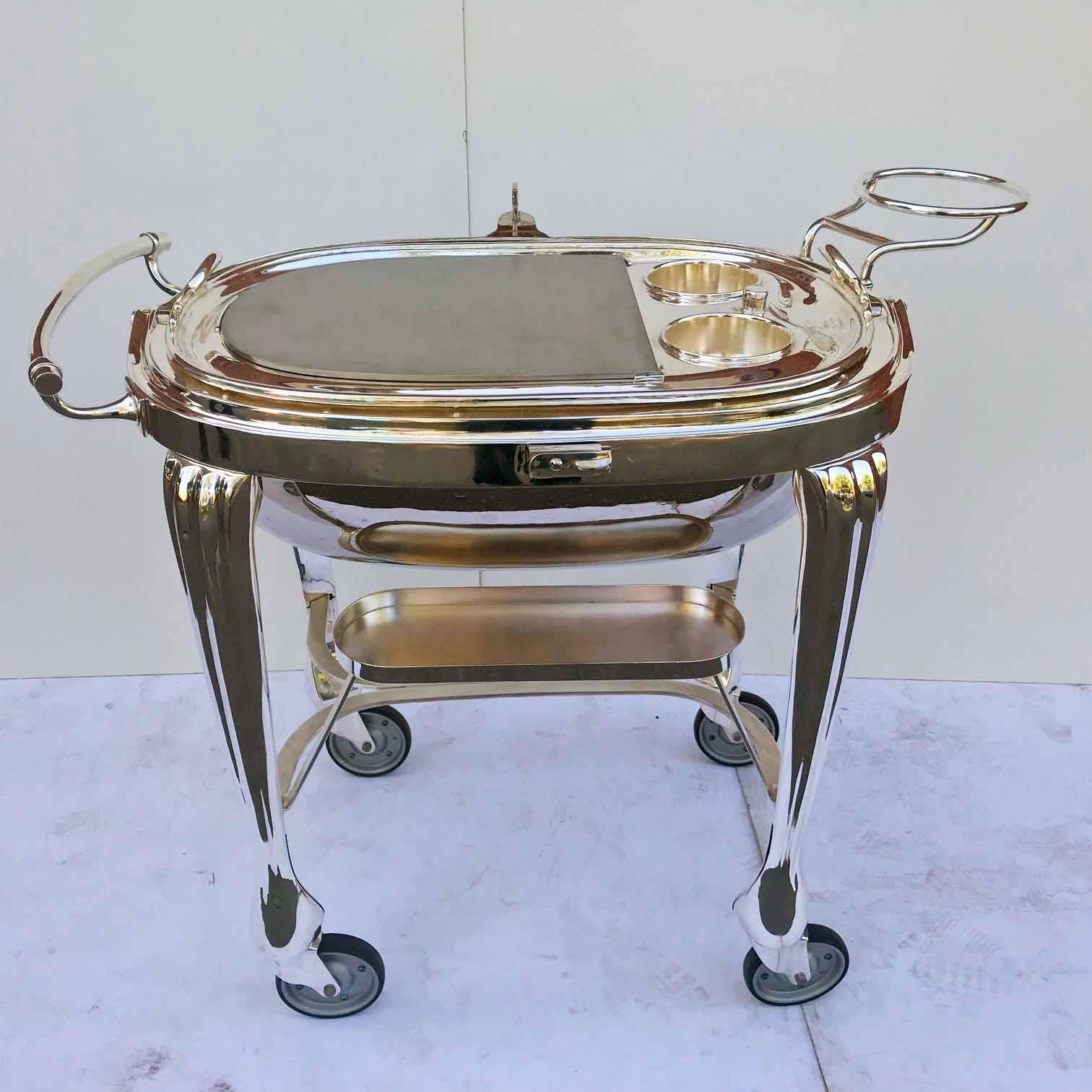 This model was produced in the 1960s and is all metal which created a more sculptural look than the partially wooden version. Essentially, it has the same form as a Victorian /Edwardian breakfast dish but more so. The carving surface is heated by a