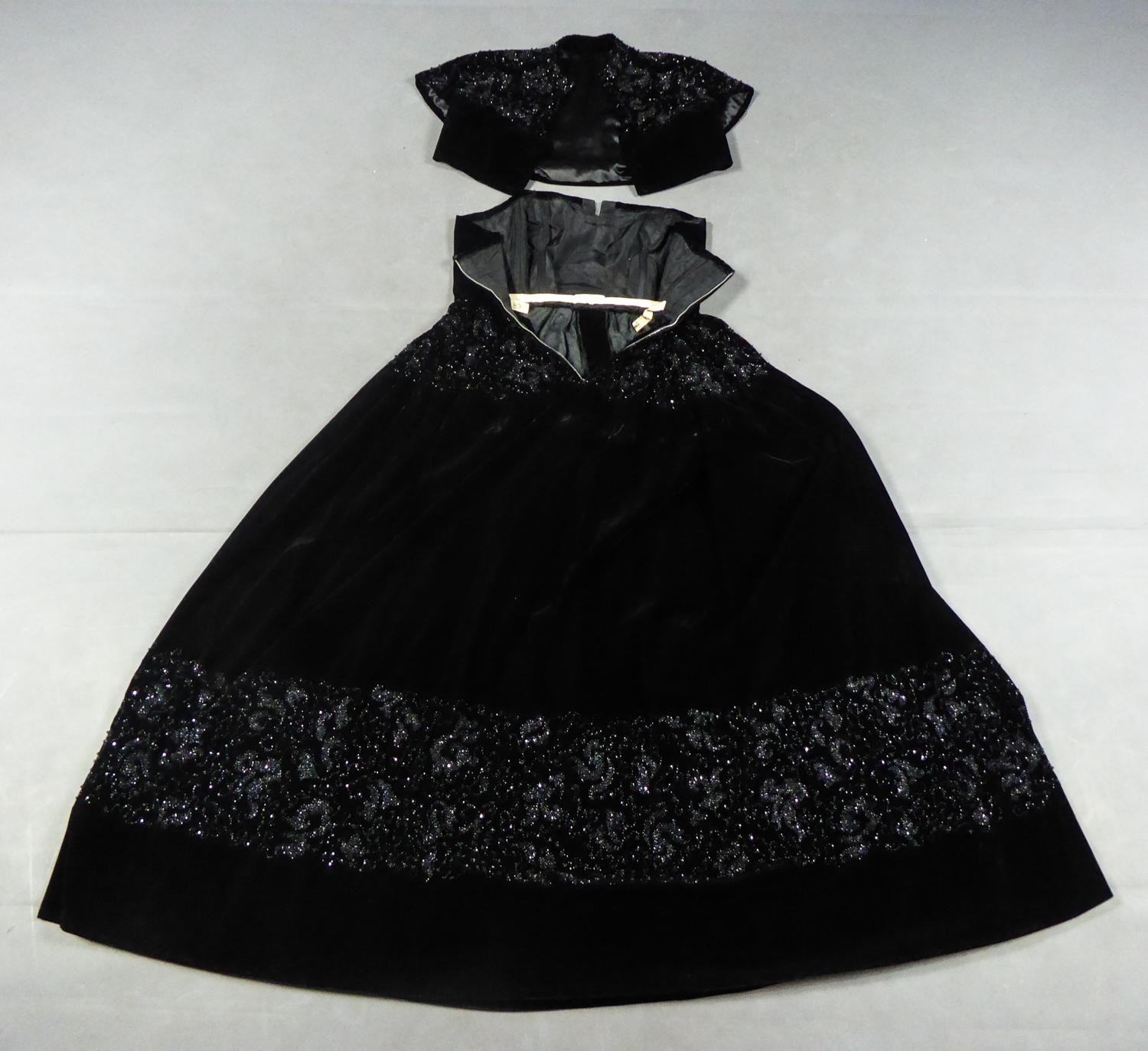 Circa 1950
France

Haute Couture evening set consisting of a dress and a bolero in black silk velvet by Maurice or Roger Worth from the early 1950s. Embroidery work on the shoulders, waist and bottom of the dress with black jet beads in volute