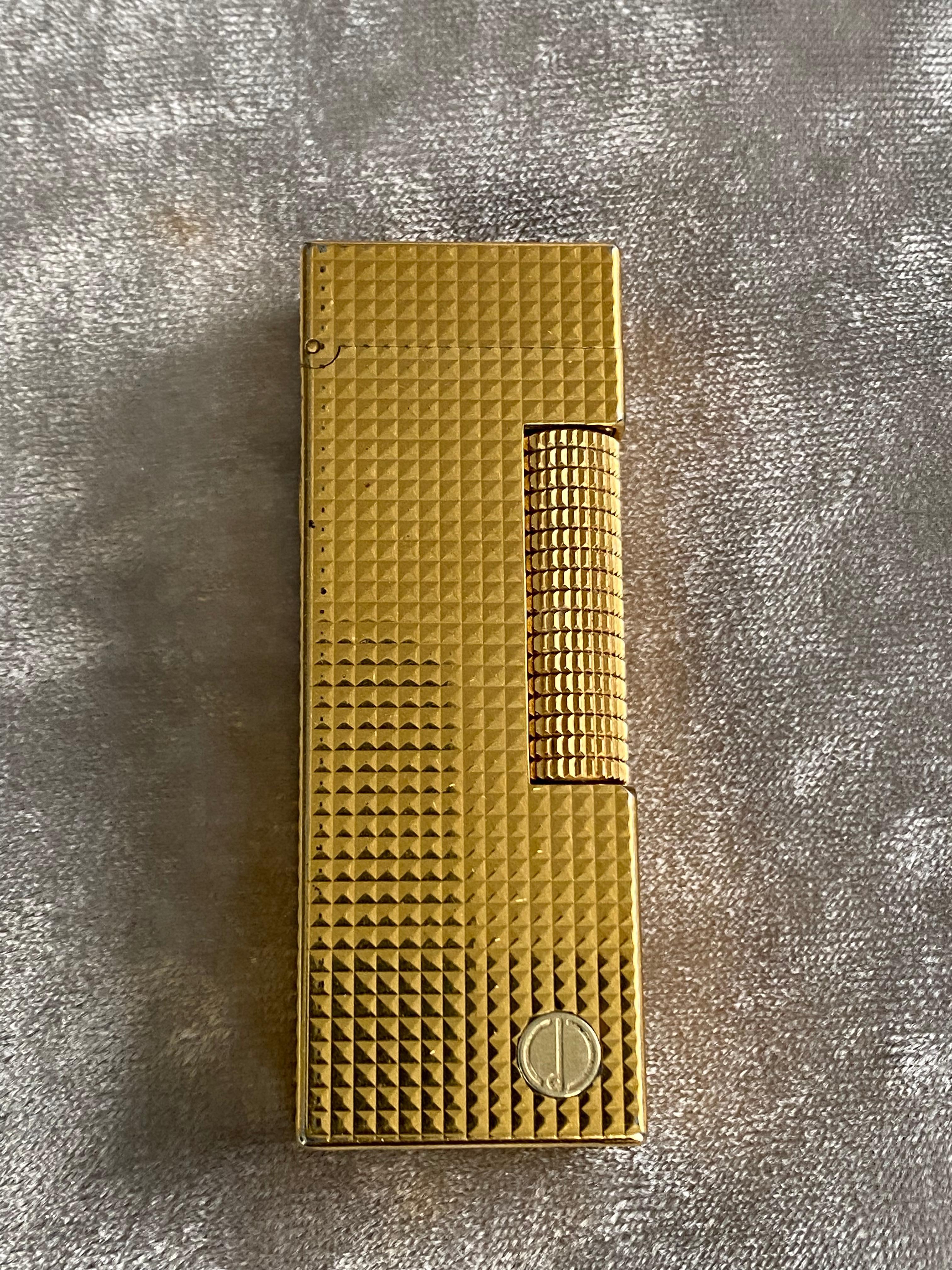 A Dunhill gold-plated mid century cigarette lighter, barley engine turned design.
Mid-Century Modern Lighter by Dunhill Rollagas Rulerlite, c1970 in mint condition. 
Almost as new. 
Please note that the lighters can not be shipped with fluid. 