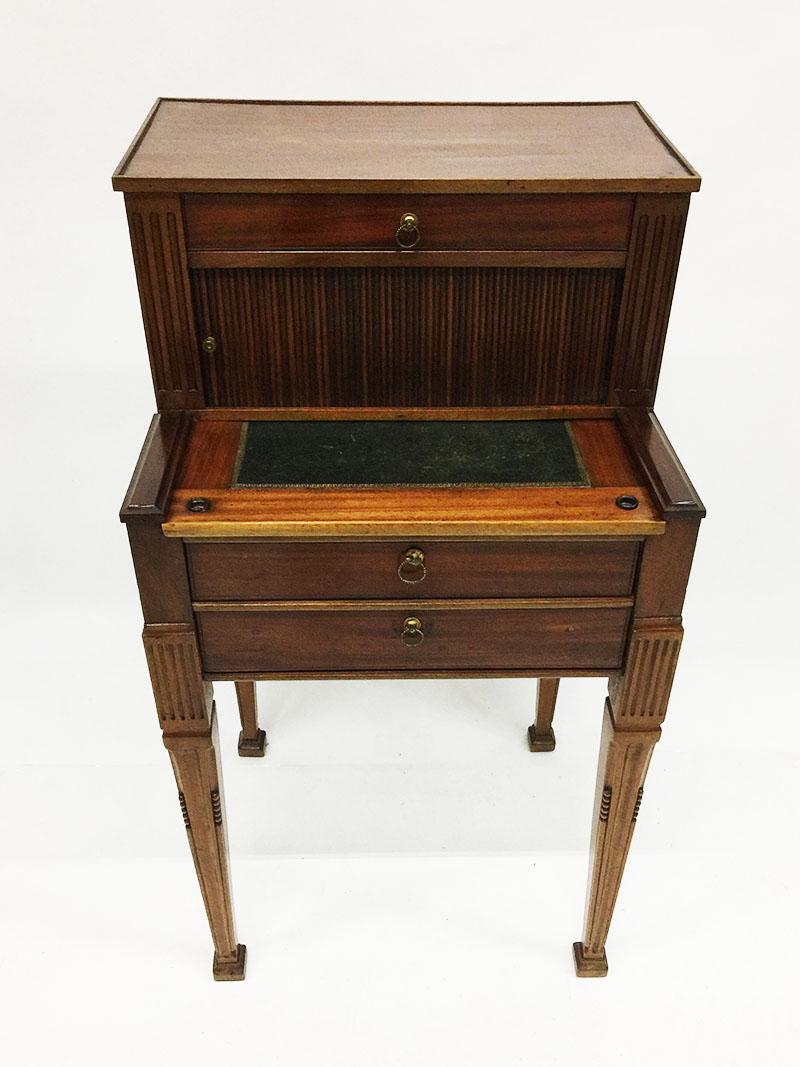 A Dutch 19th century mahogany ladies desk 

A mahogany ladies desk with green leather in the wood of the desktop with gold print. The desk has 3 drawers, one at the top and two below.
Wooden (mahogany) sliding doors at the desktop,

1840-1860,