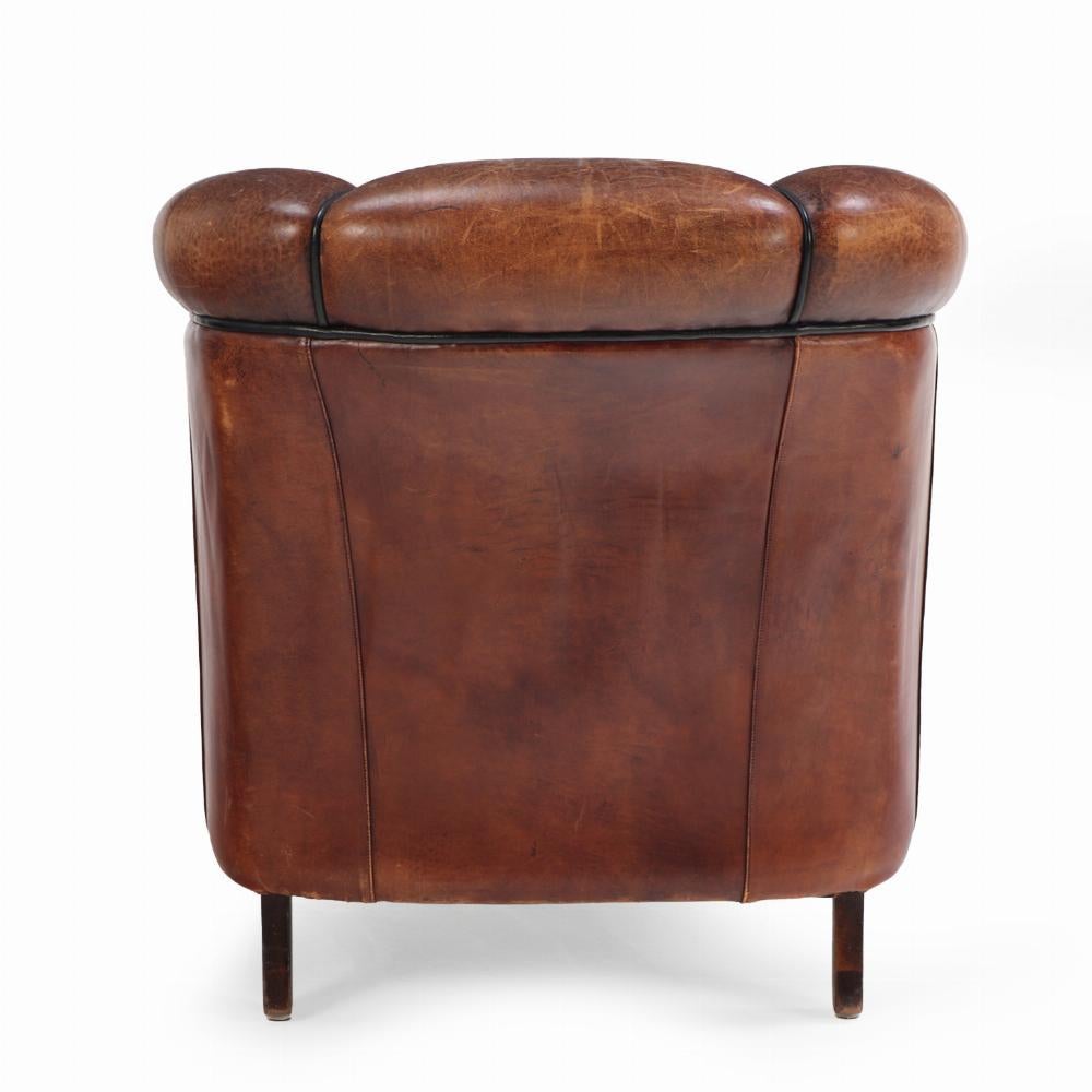 With a vertically tufted backrest that adds both visual interest and supportive comfort, this chair’s classic, deep seat and gently curved and rolled arms embody the inviting proportions of traditional club chairs. Raised on square tapering wooden