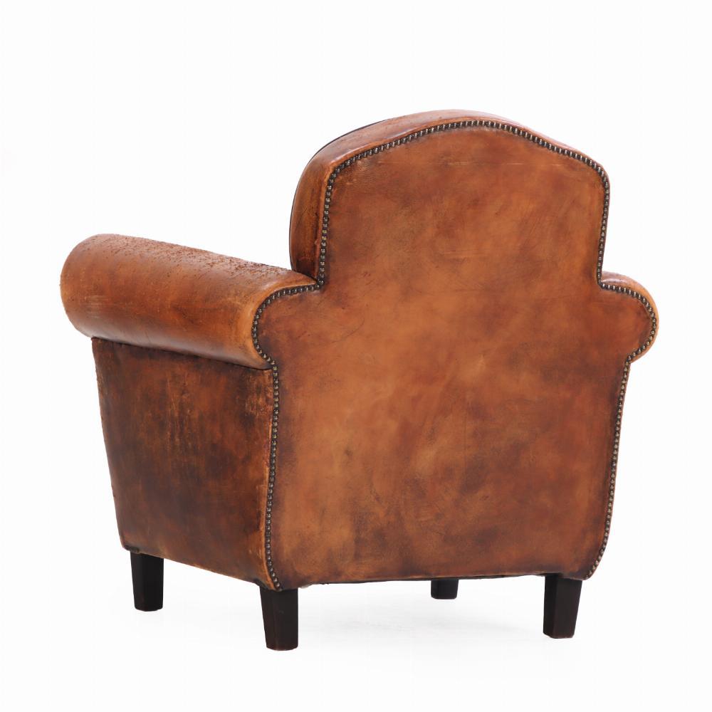 Upholstered in rich, patinated leather that beautifully reflects its age and use, this chair features a classic, generously proportioned silhouette with a deep seat and gently rounded back for comfort and support. Set on square, tapering wooden