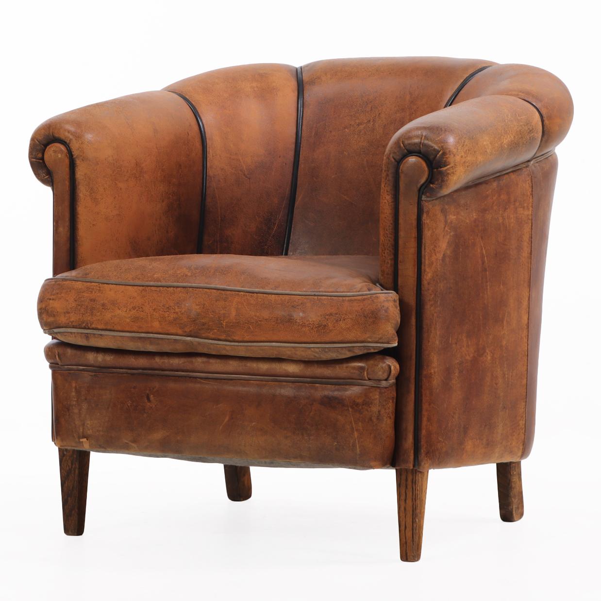 Con un respaldo de mechón vertical acentuado por un elegante ribete negro que añade tanto interés visual como comodidad de apoyo, el asiento clásico y profundo de esta silla y sus brazos suavemente curvados y enrollados encarnan las atractivas