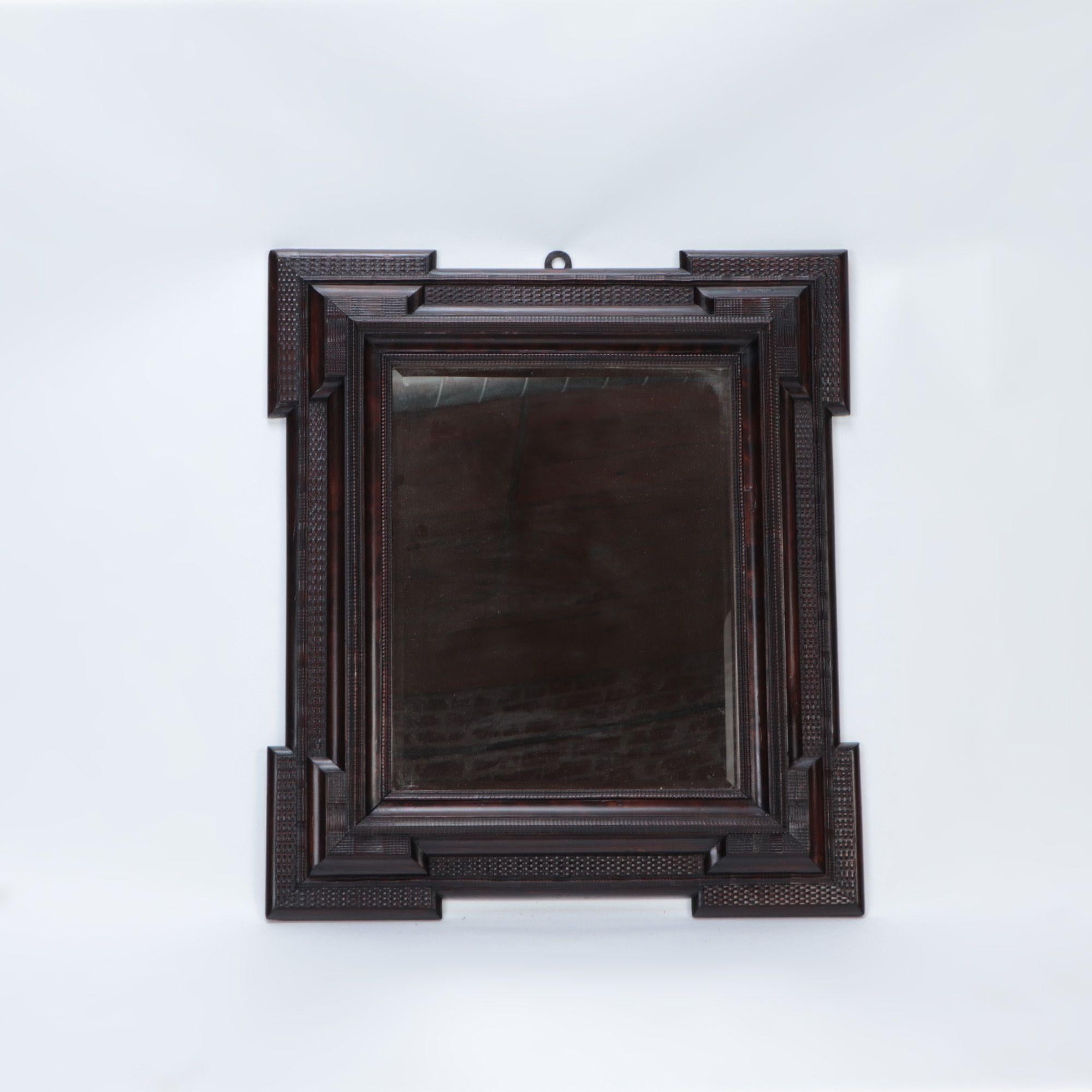 A Dutch blackened and carved wood framed mirror, 19th century.