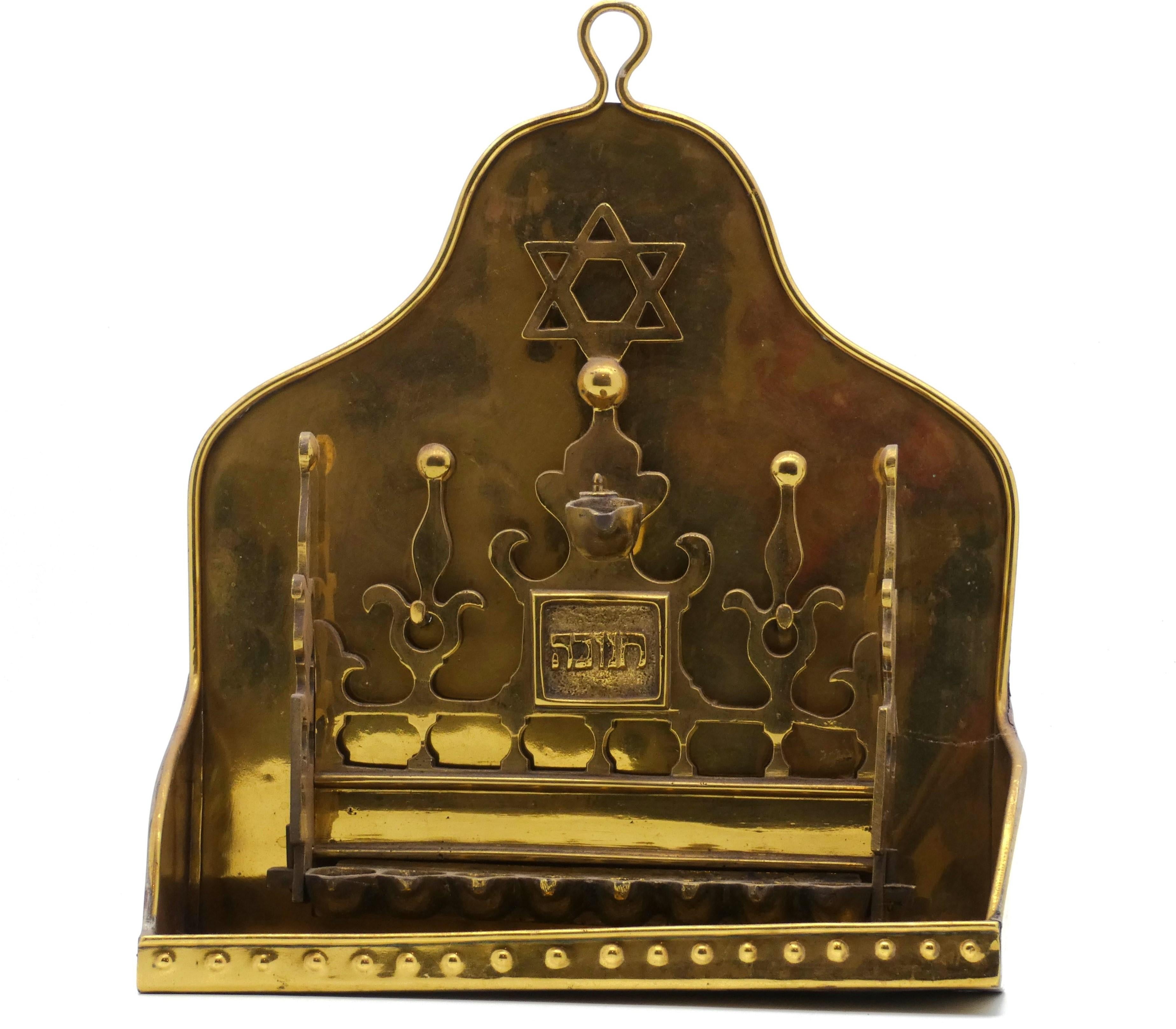 Dutch Brass Hanukkah Lamp, early 20th century made in an 18th-century style.

Hannukah Lamp has two backplates, the fore plate  is pierced with stylized fleurs de lys with ball finials on its upper portion and side panels.

Mounted at top of the
