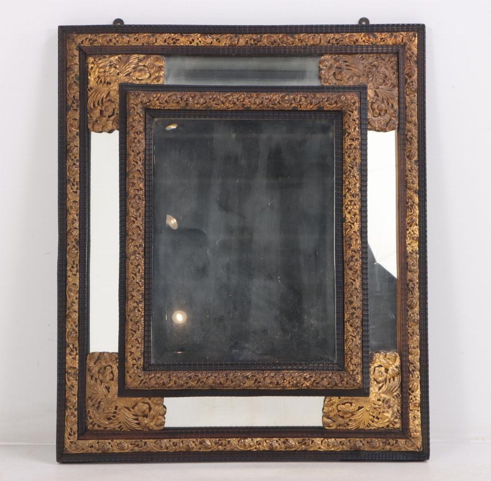 A Dutch brass repousse mirror, 19th C. having ebonized ripple carvings and applied brass decoration.