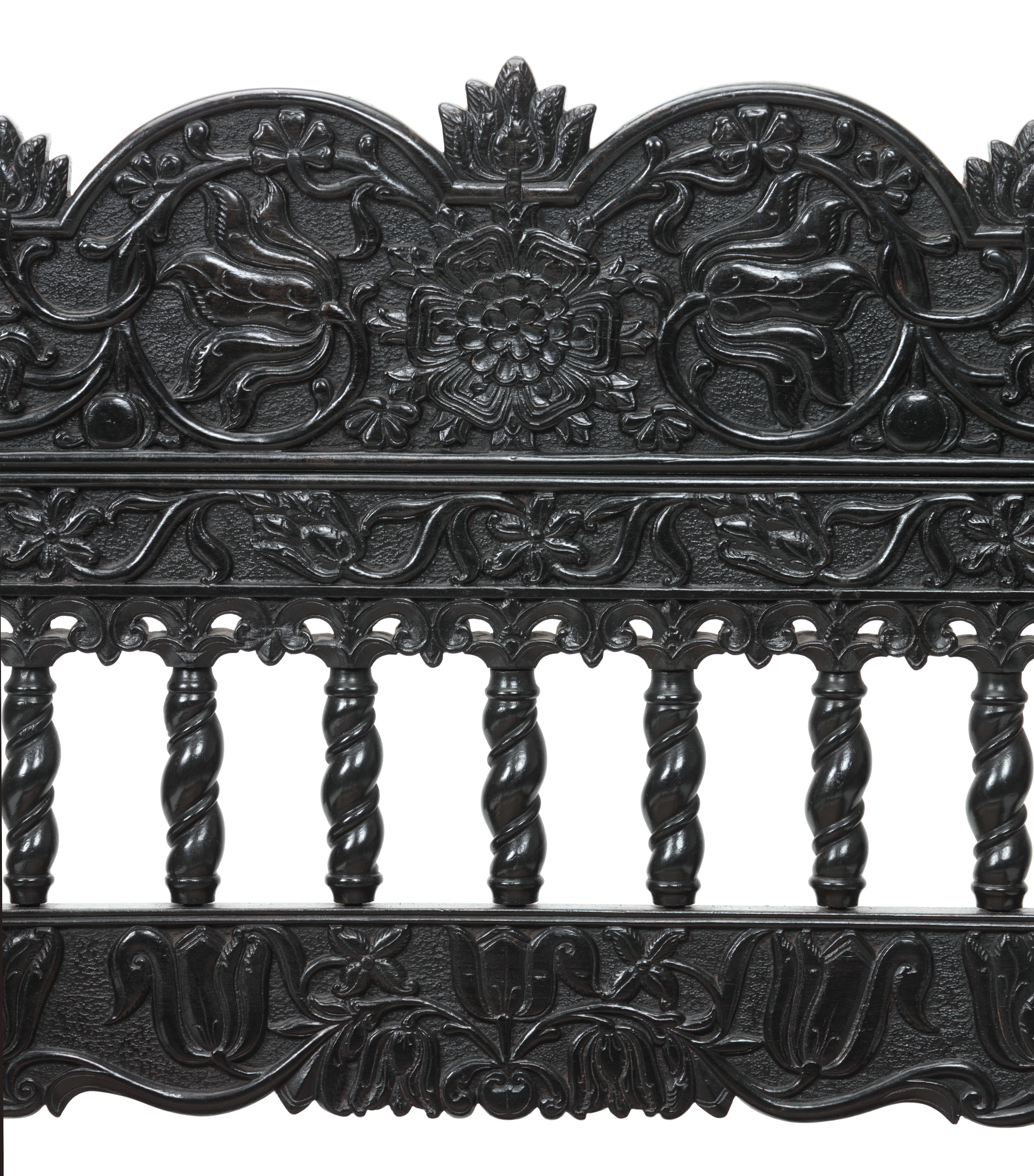 An unusual Indian half-relief carved ebony armchair

 

Coromandel coast, 1680-1700

?

Throughout carved with floral and vine motifs, the back rail with a central peony and two bulbous finials, with cane seating.

 

Measures: H. 81 x