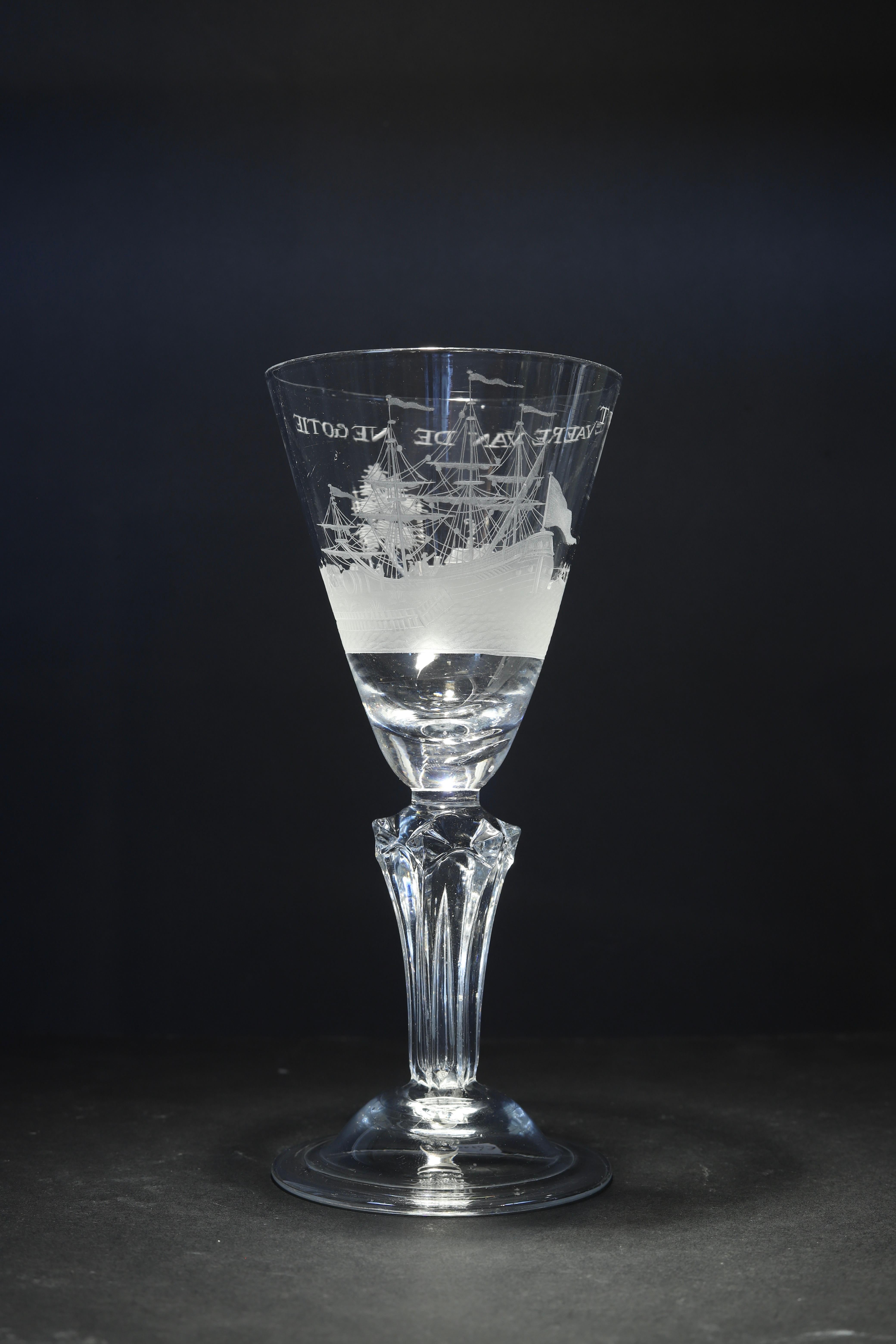The Netherlands or England
Engraving: Dutch
Circa 1730 - 1740

An exceptional fine Dutch engraved moulded stem wine glass, with a pointed round funnel bowl with a solid base enclosing a tear, decorated with a continuous harbor scene depicting a
