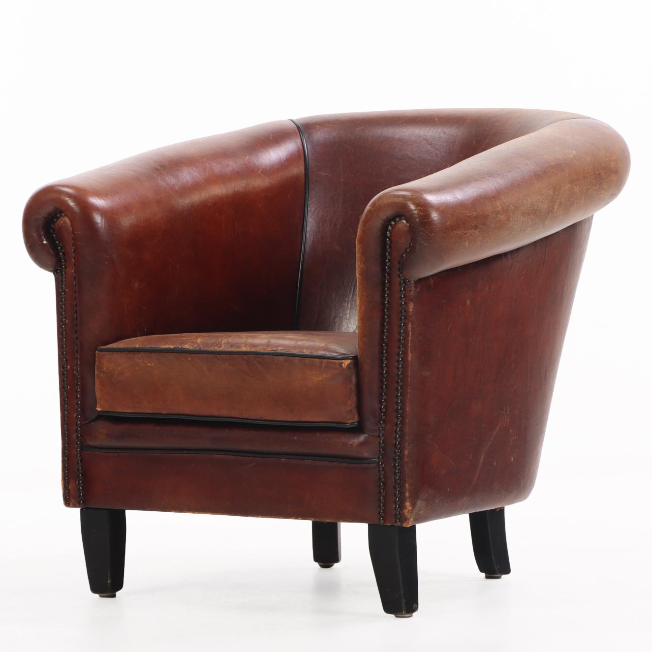 Dieser Clubsessel aus Leder ist ein wahrer Luxus! Mit seiner abgerundeten Rückenlehne, den gerollten Armlehnen mit Ziernägeln und der kontrastierenden schwarzen Zierleiste bietet dieser Stuhl einen wunderbaren Sitzkomfort und ein zeitloses Aussehen.