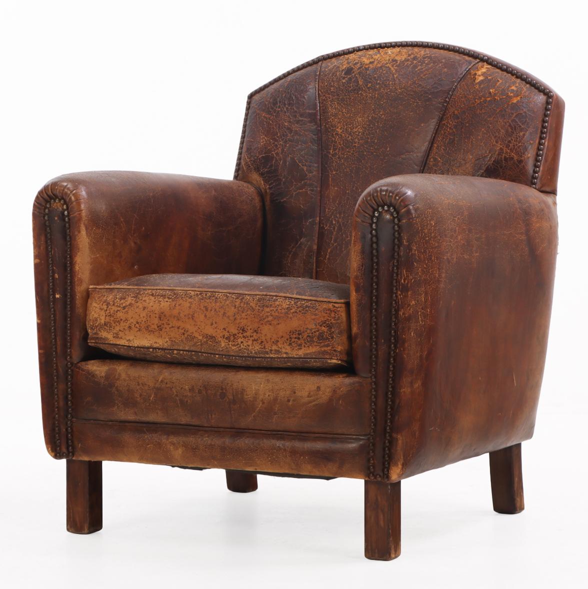Ce magnifique fauteuil club en cuir de style Art déco est un véritable symbole de luxe ! Avec son dossier arqué, ses fins accoudoirs arrondis et ses clous décoratifs, ce fauteuil offre un confort d'assise exceptionnel et une apparence intemporelle.
